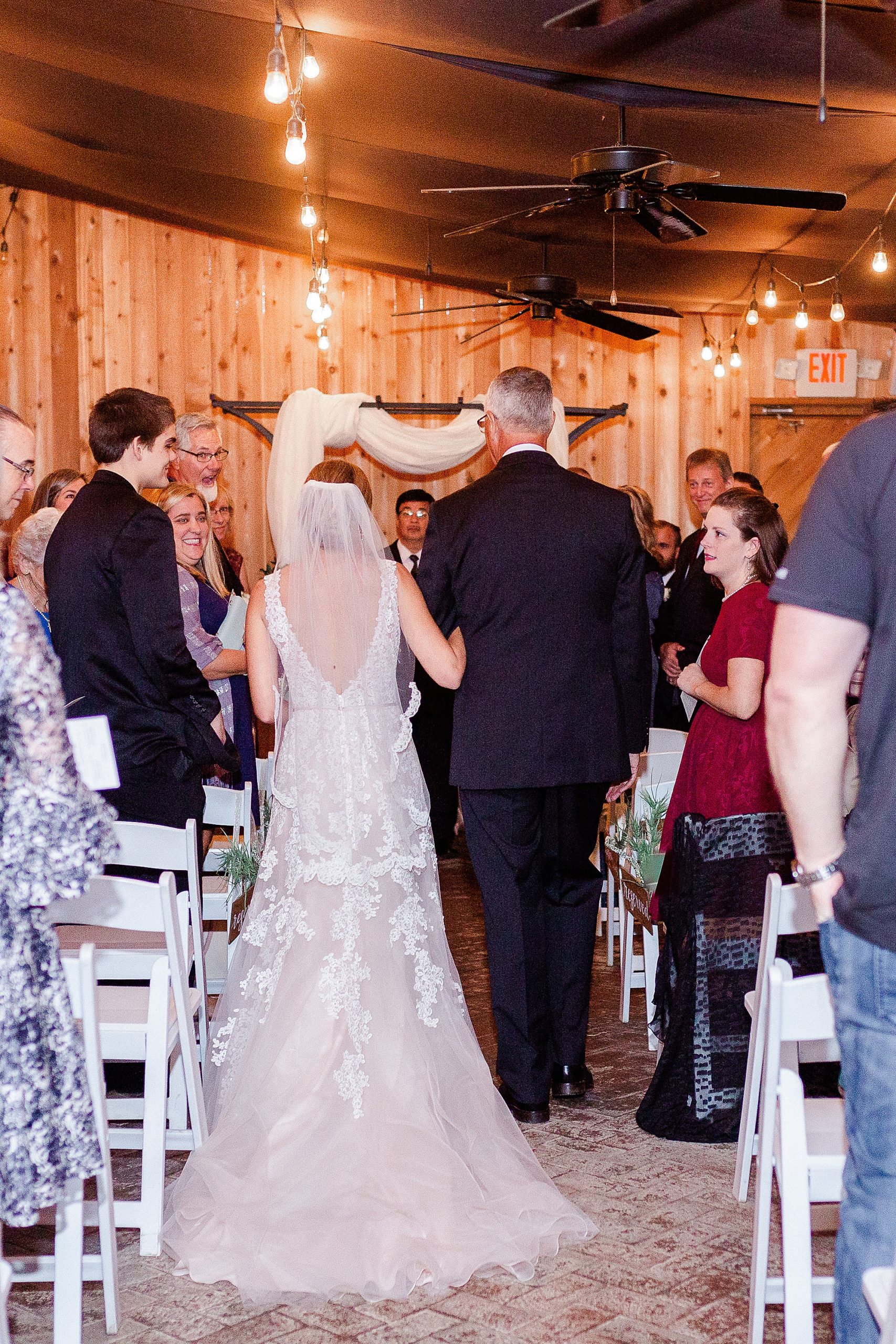 bride walks down the aisle with dad during Alexander Homestead wedding ceremony
