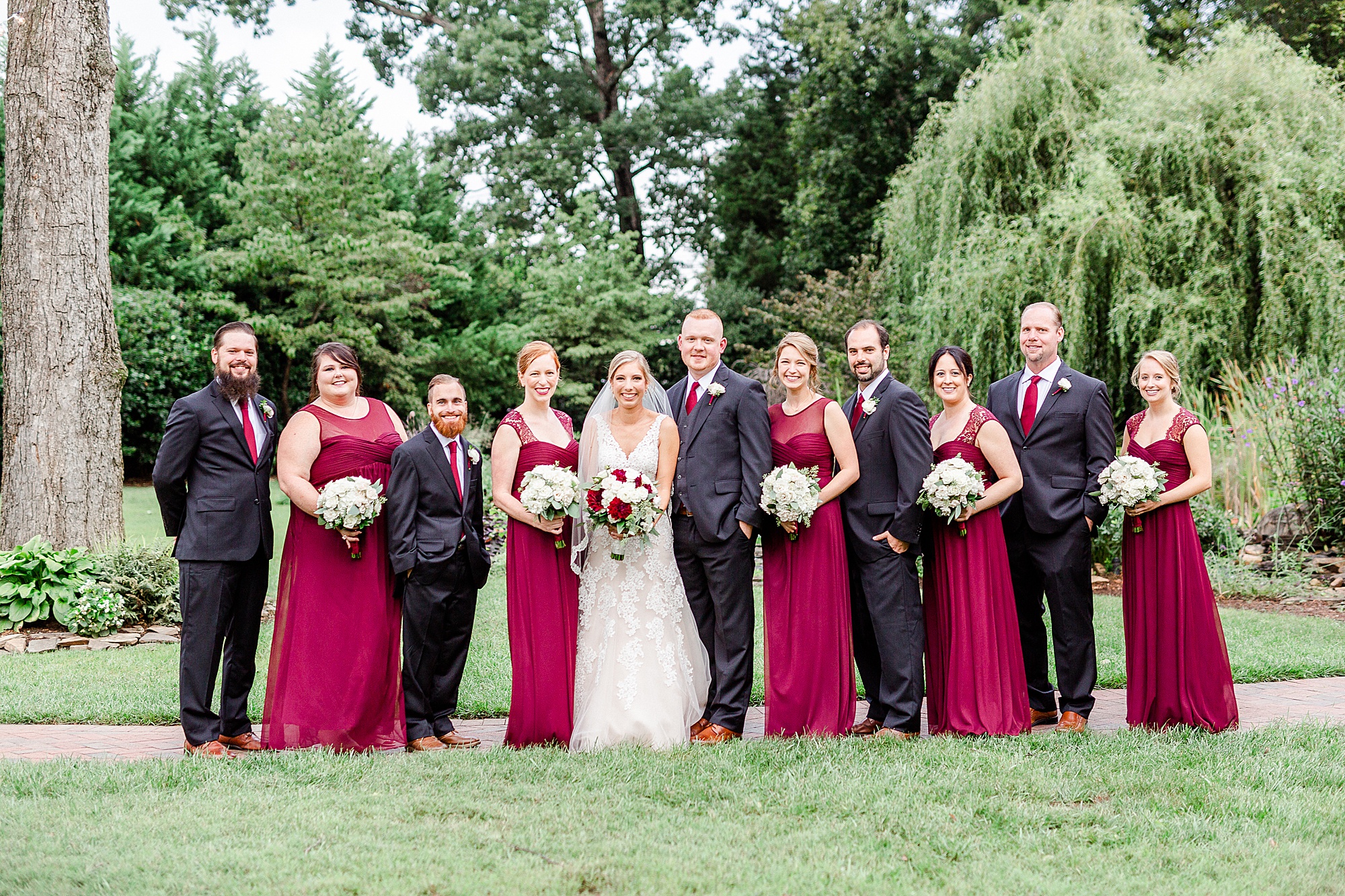 newlyweds pose with bridal party in red and black