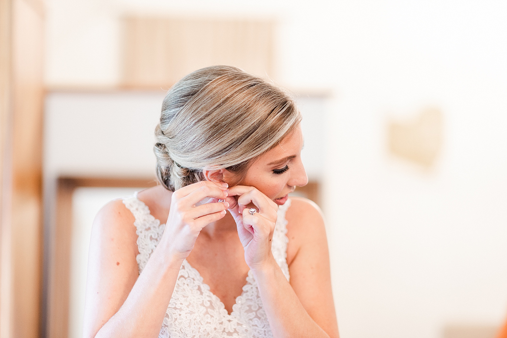 bride adjusts earrings before NC wedding