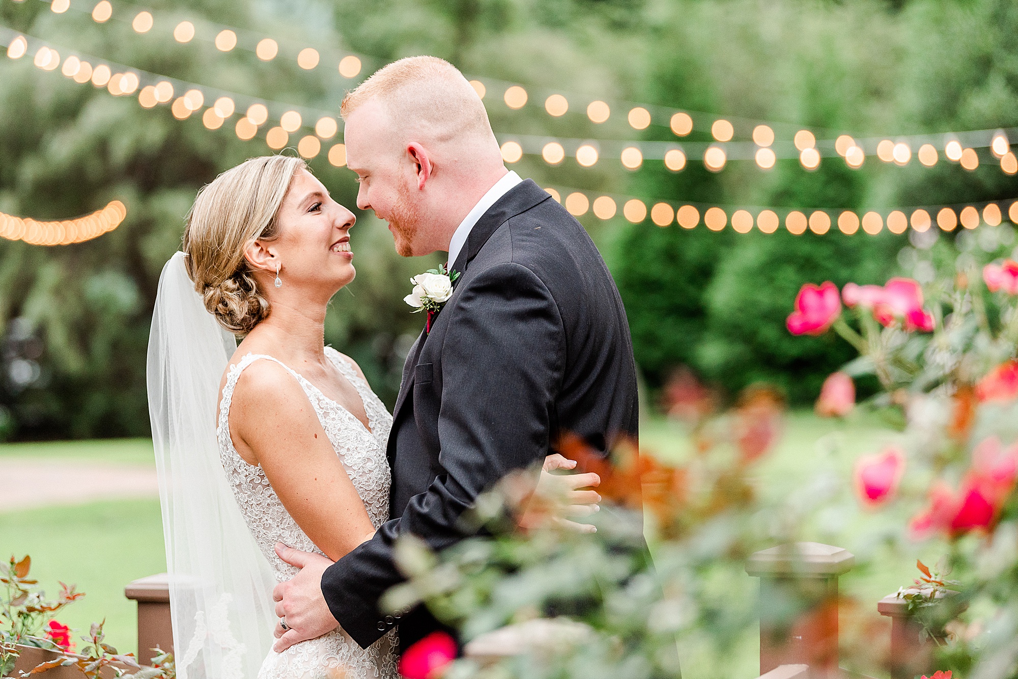bride and groom stand nose to nose in gardens at Alexander Homestead