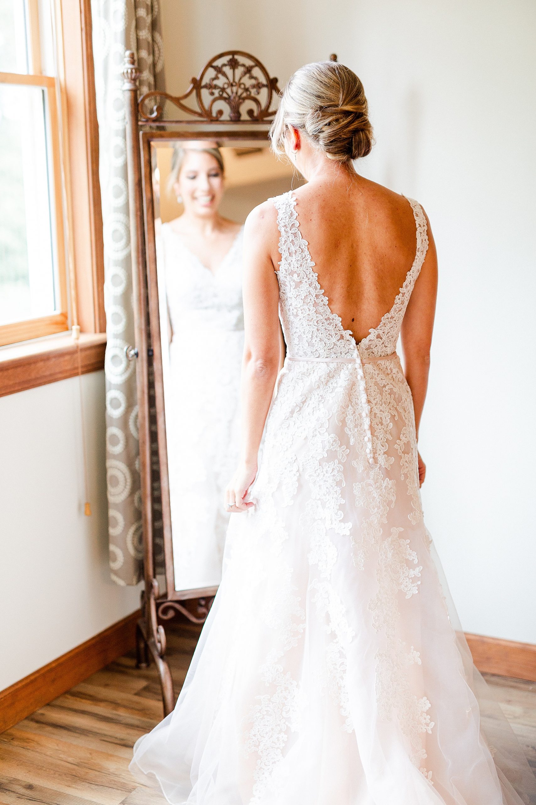 bride looks at reflection in mirror at Alexander Homestead bridal suite