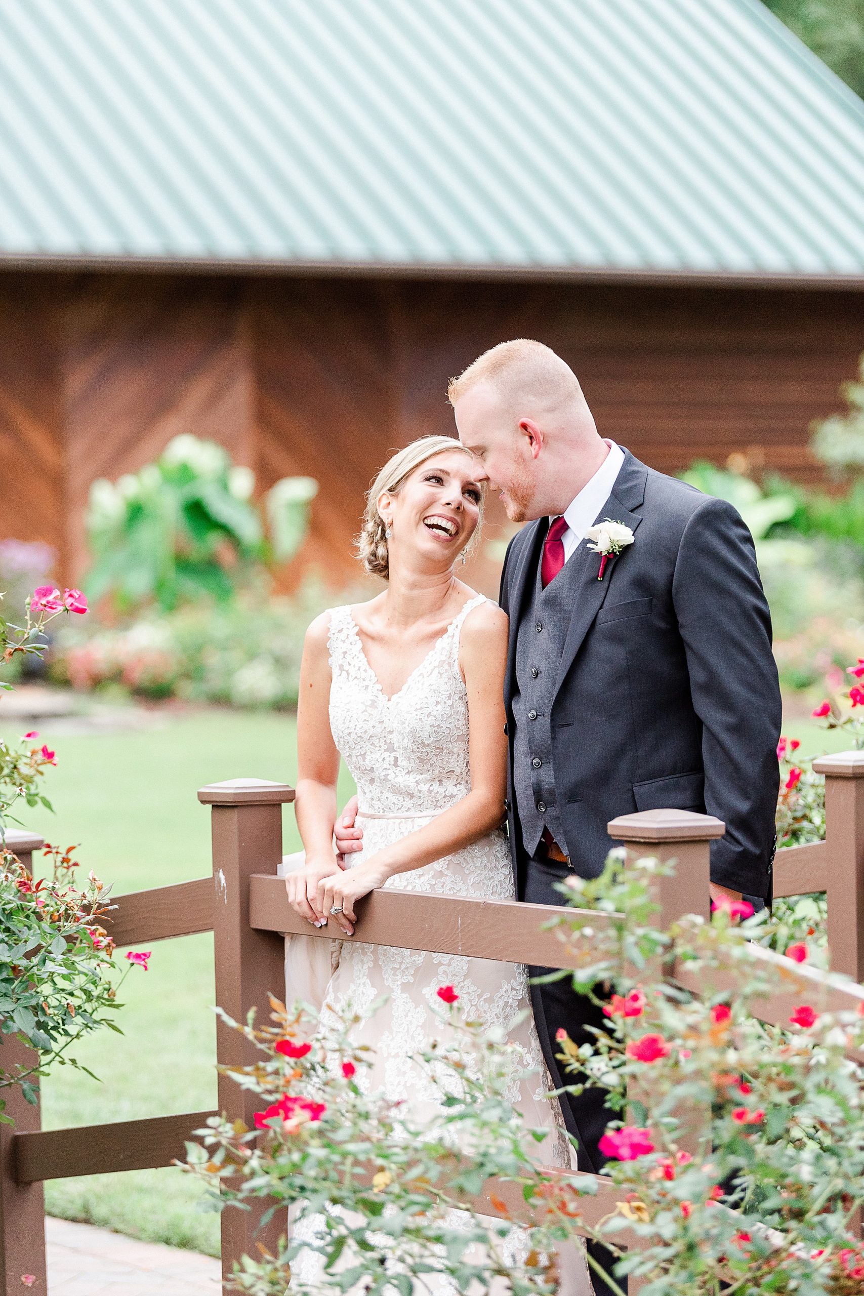 bride looks up at groom and laughs during wedding photos at Alexander Homestead