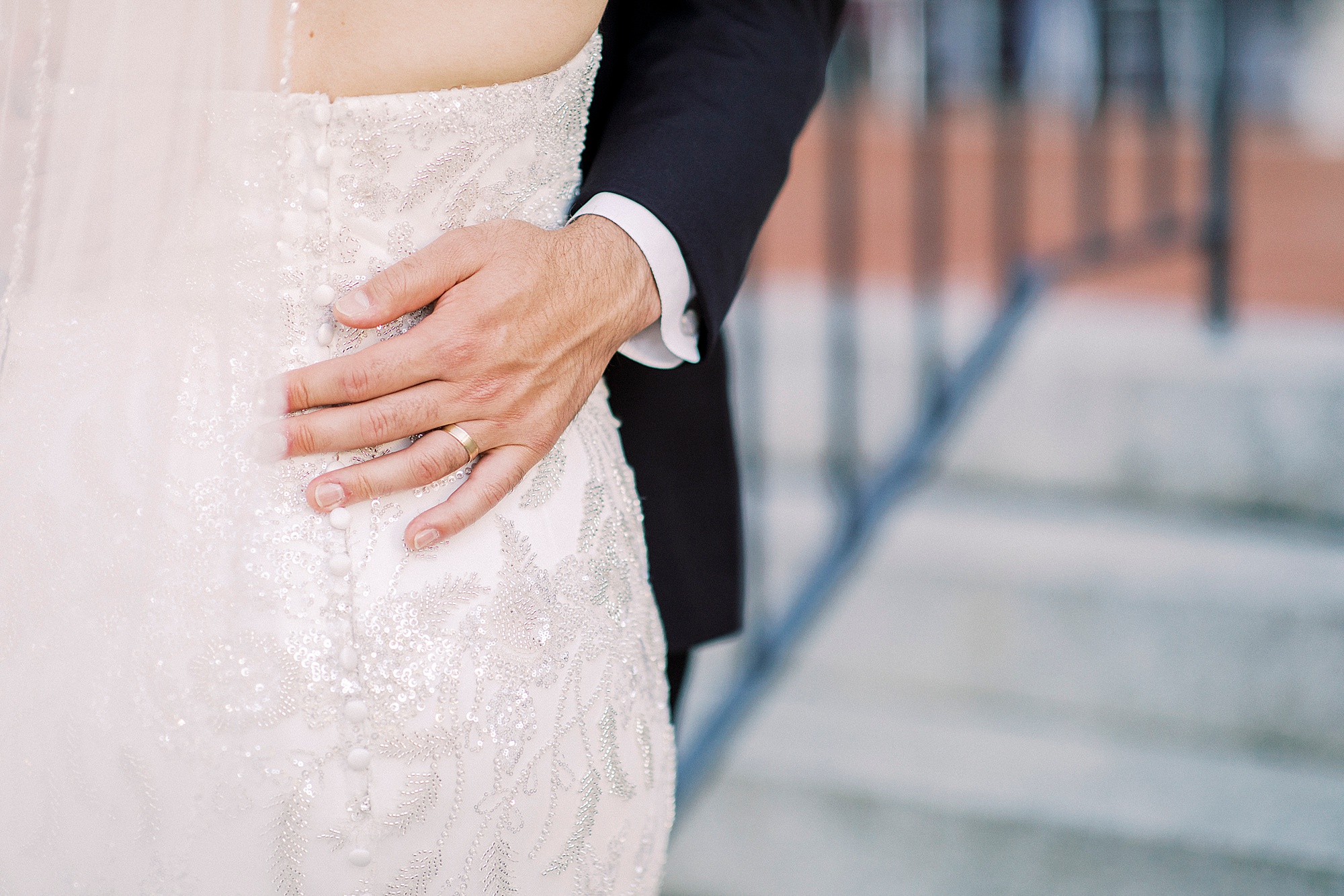 groom holds bride's waist during wedding photos