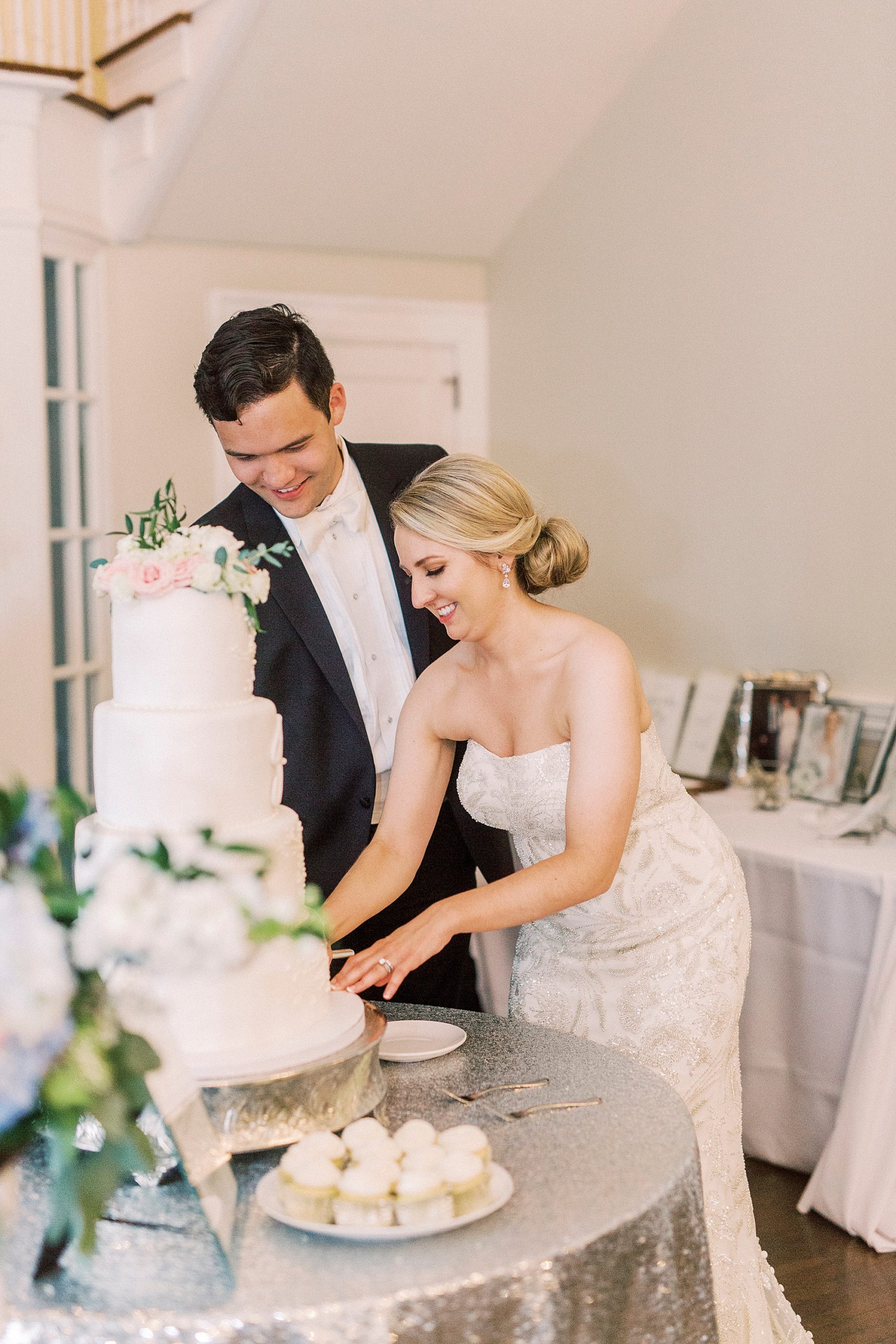 bride and groom cut wedding cake during elegant Charlotte wedding reception