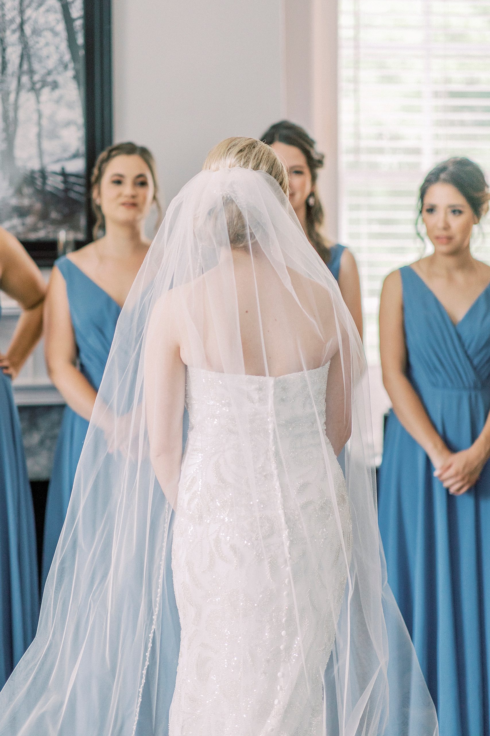 bride has first look with bridesmaids in light blue gowns