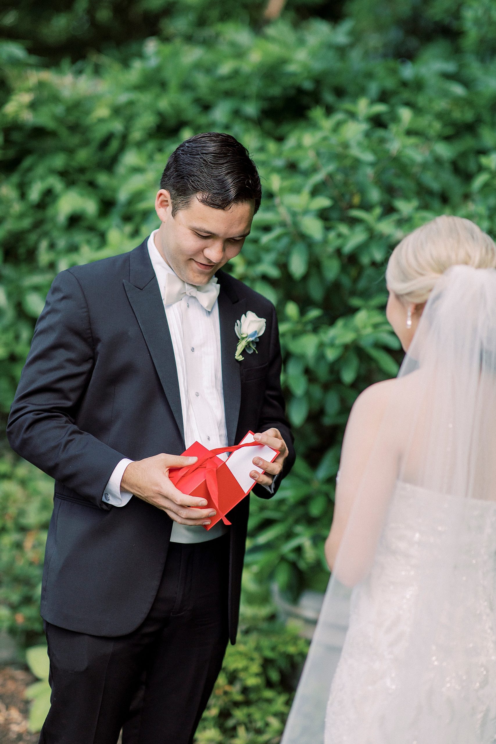 groom opens gift from bride during first look