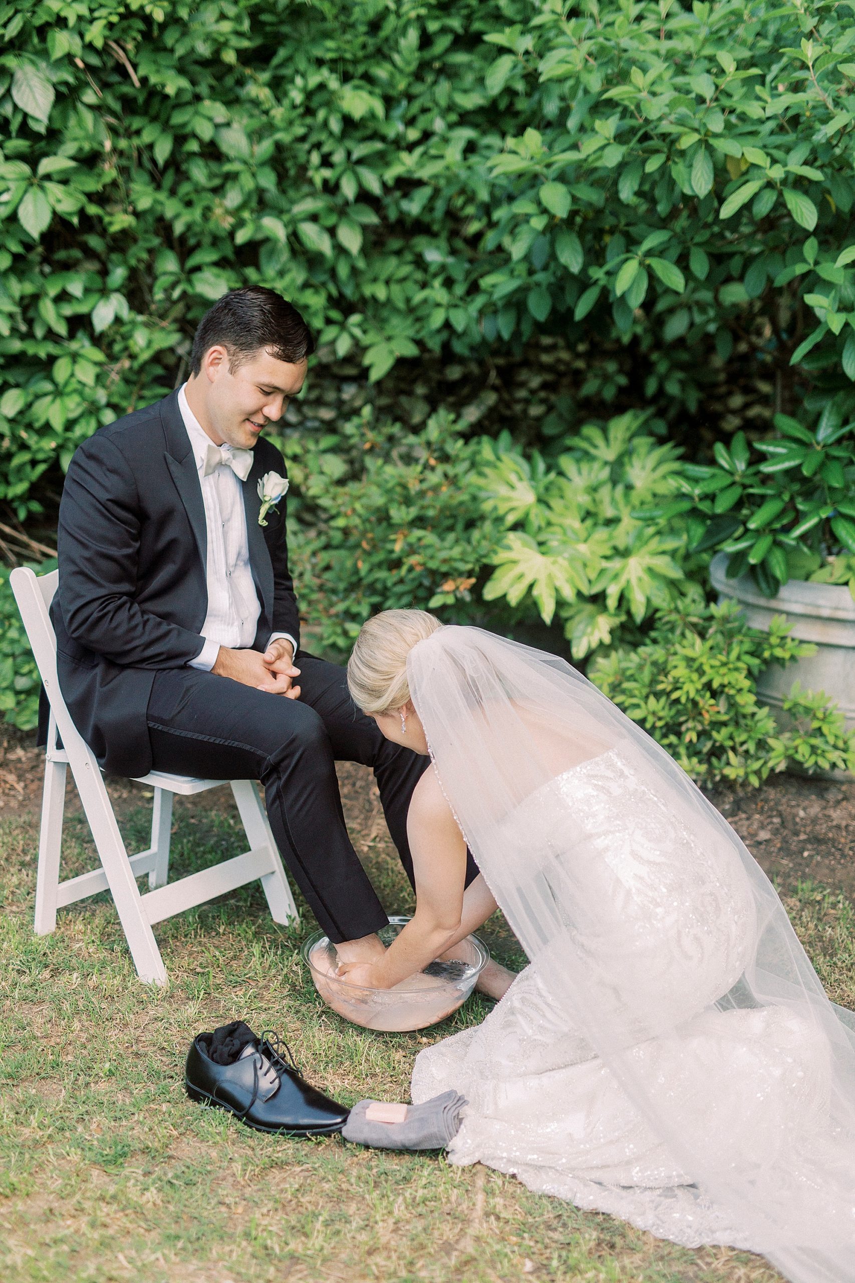 bride washes groom's feet during foot washing ceremony