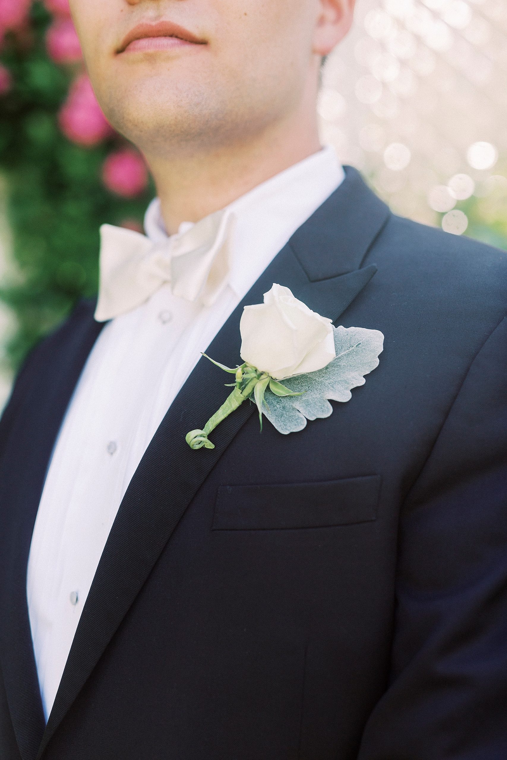 groom shows off ivory wedding boutonnière
