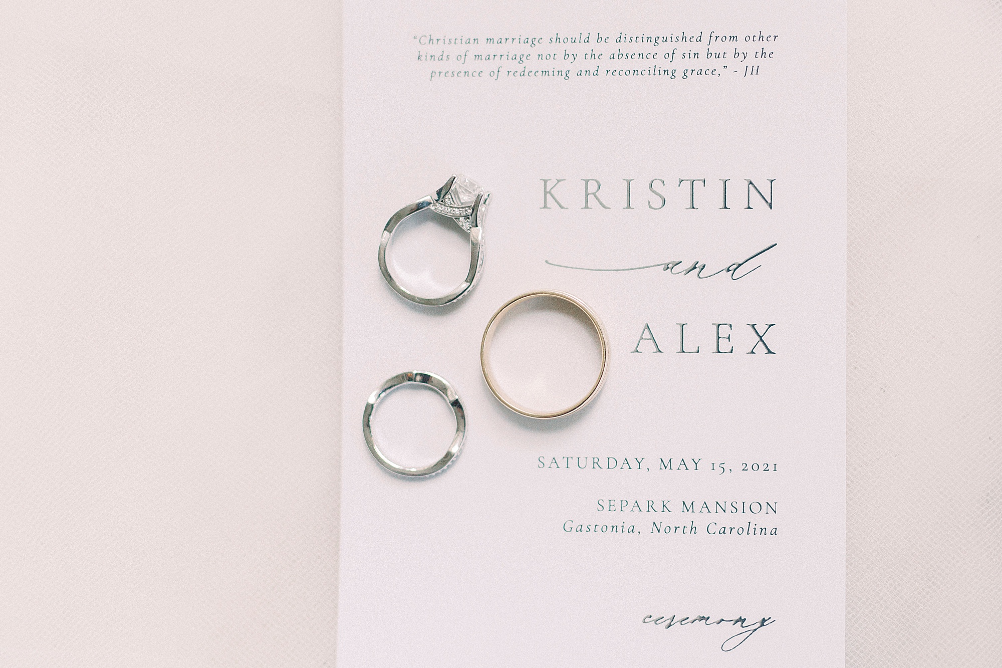 wedding rings rest on invitation suite