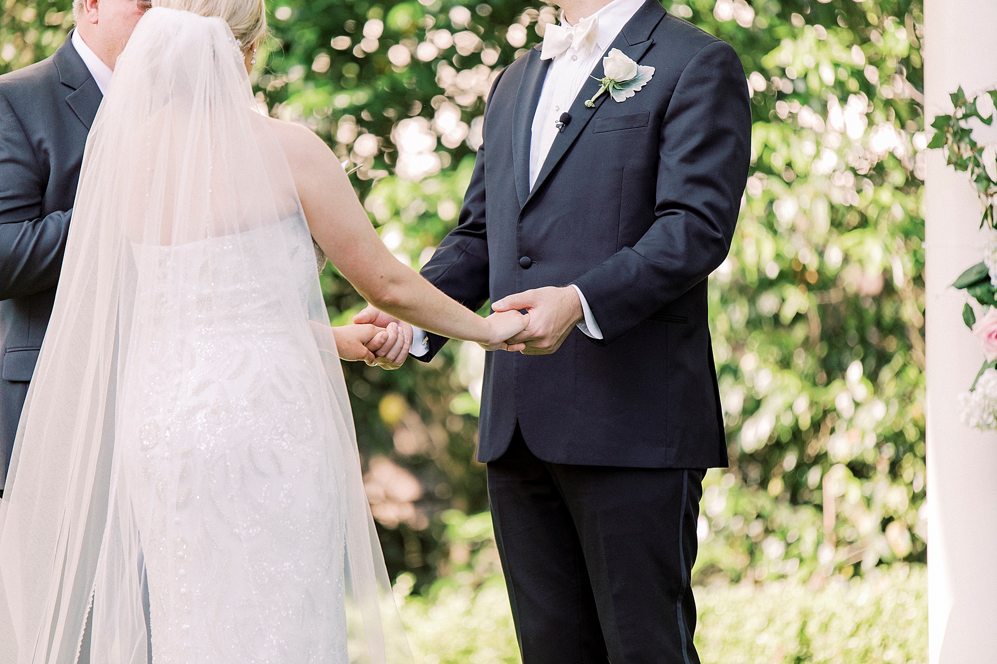 newlyweds hold hands during outdoor wedding ceremony at Separk Mansion