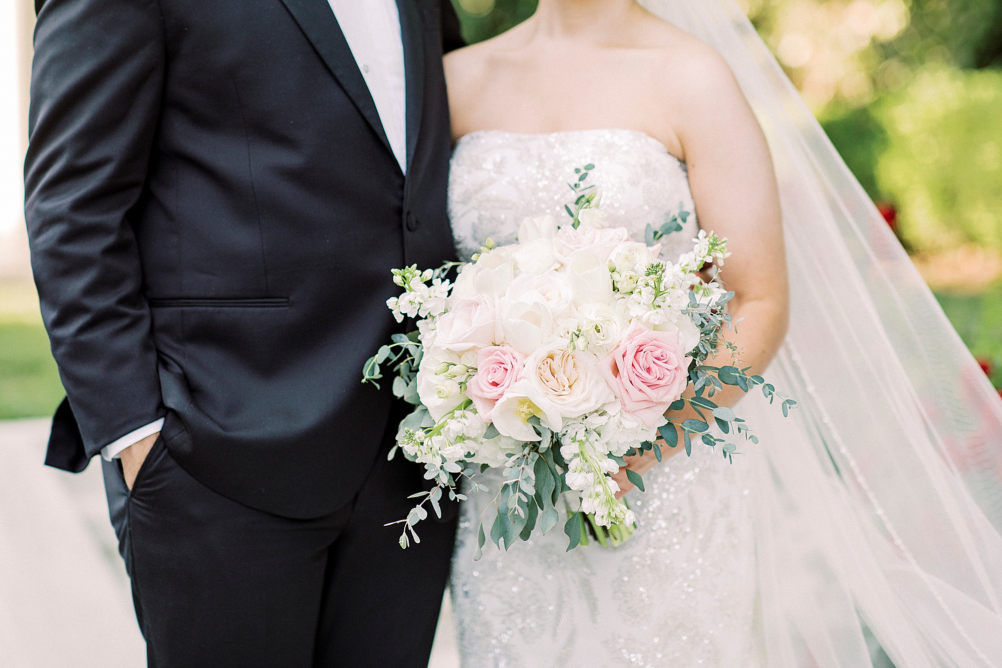 bride and groom hold bouquet