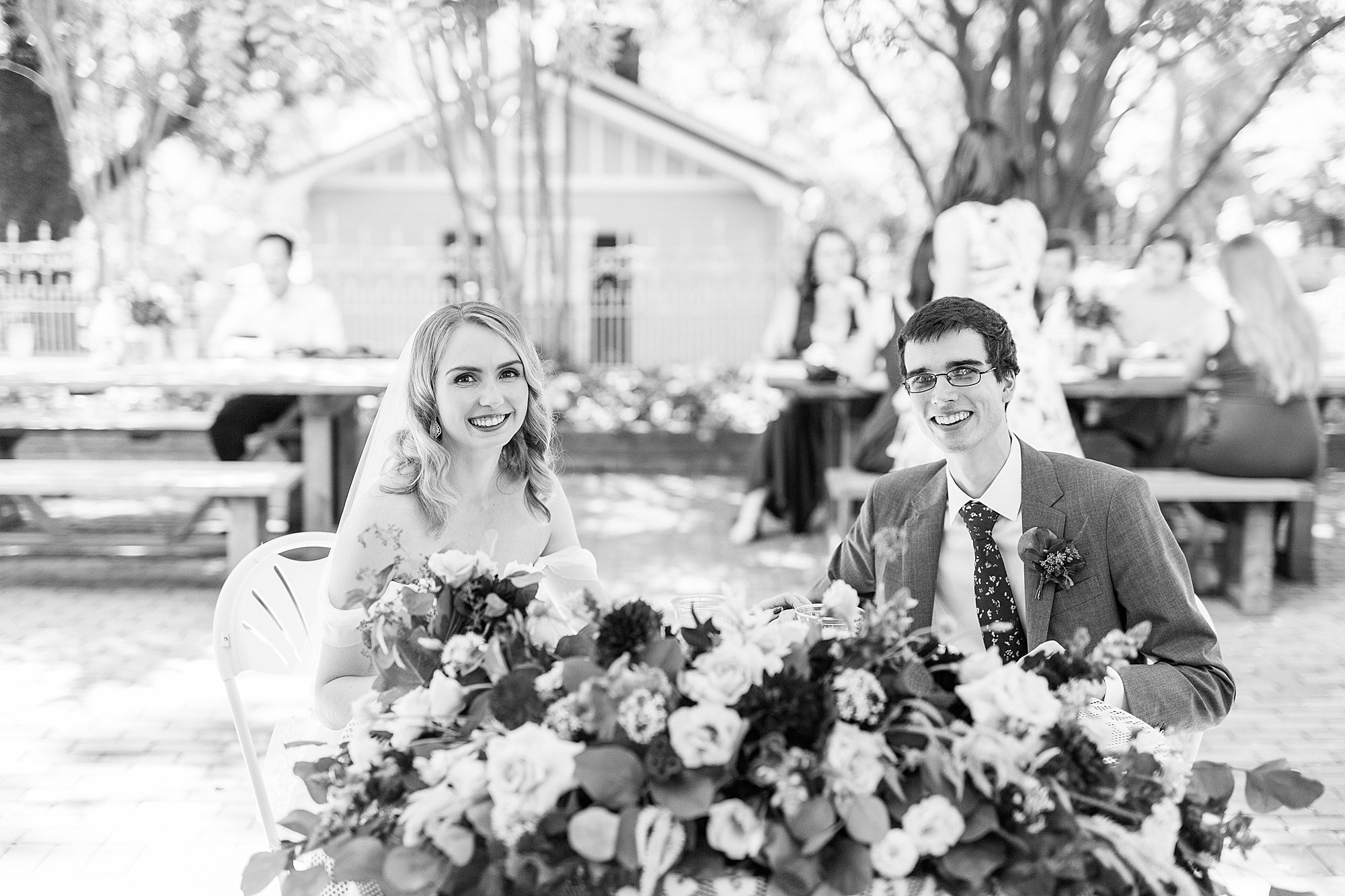 bride and groom sit at sweetheart table in NC