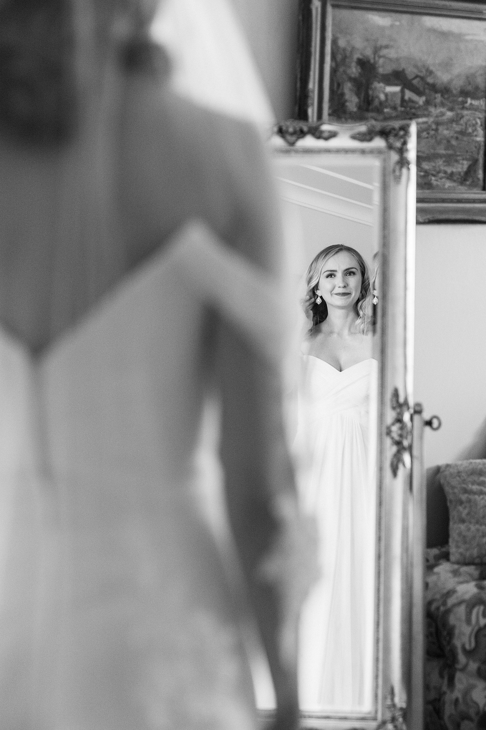 bride looks at reflection in mirror at 1812 Hitching Post