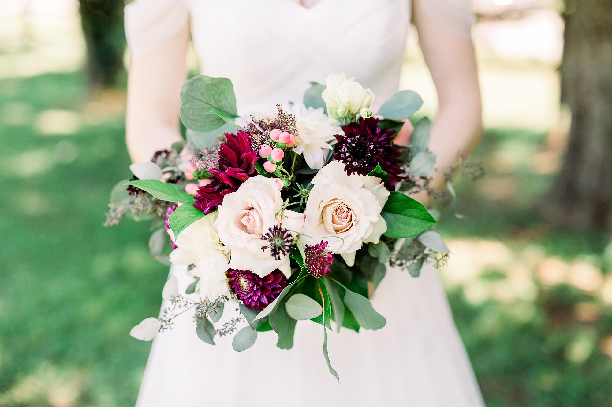 bride holds bouquet of pink and red flowers