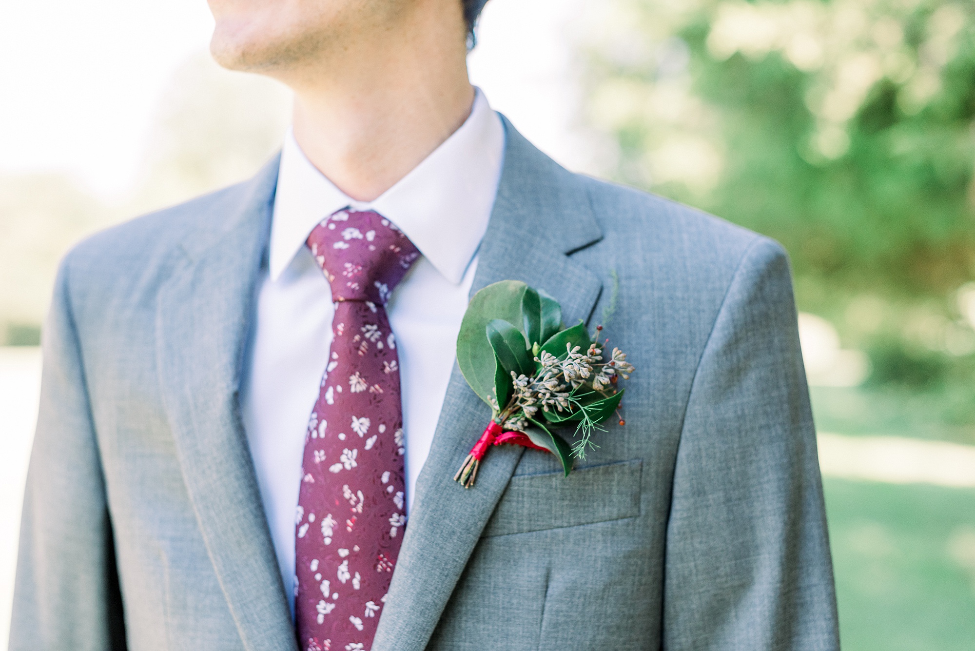 groom's maroon tie with simple boutonniere
