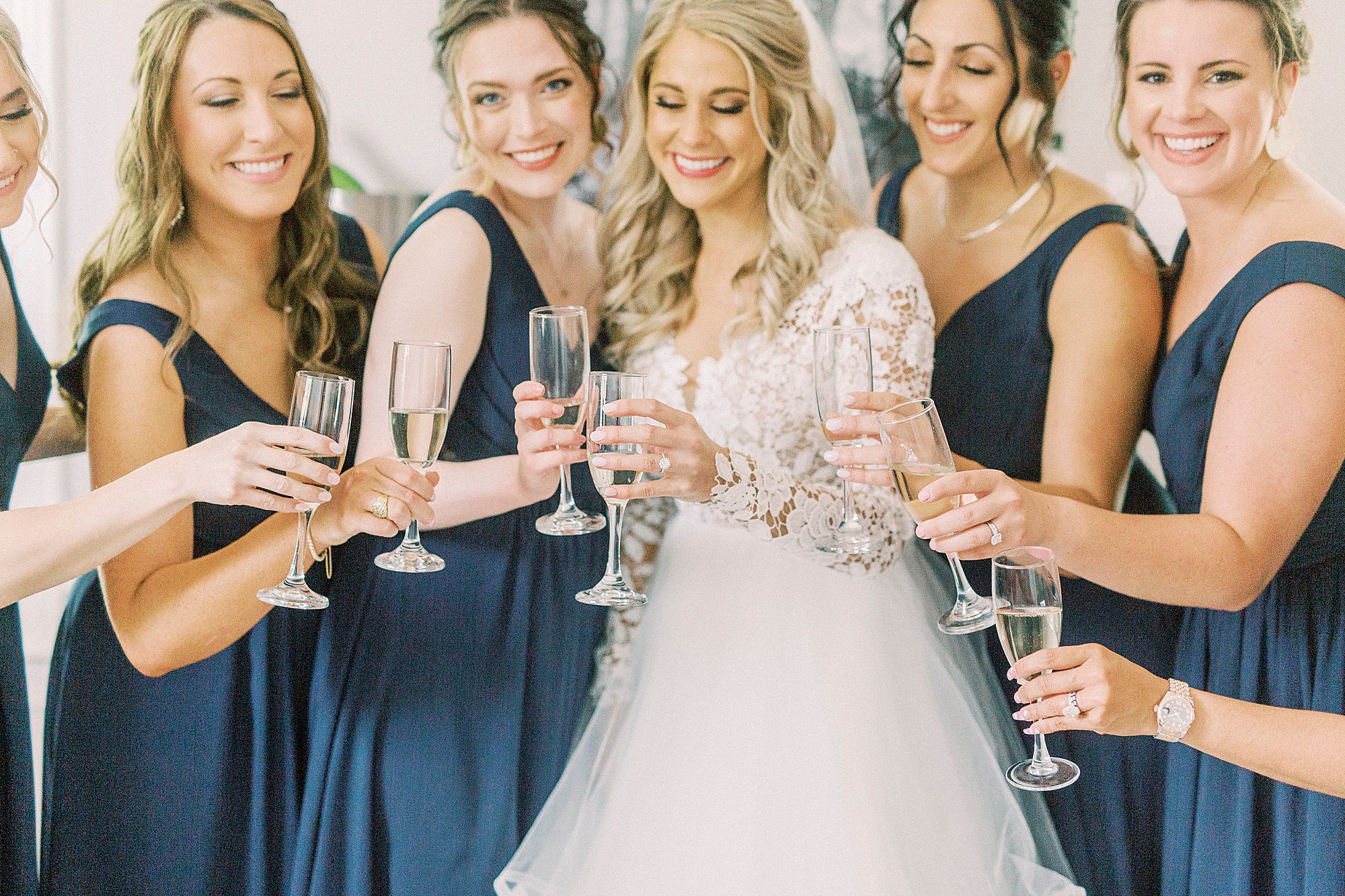 bride and bridesmaids toast with champagne glasses
