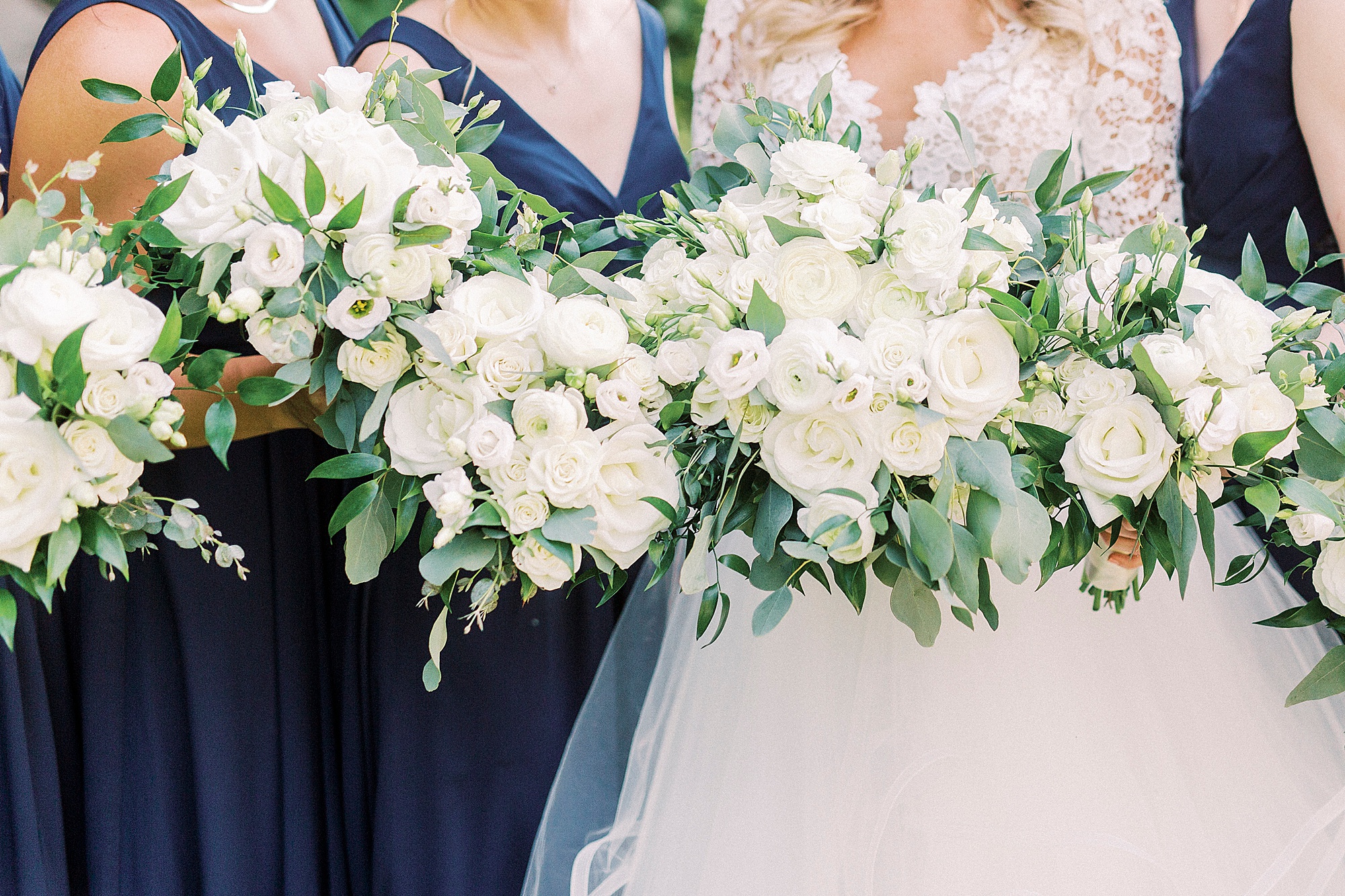bridesmaids in navy dresses hold all-white bouquets at Separk Mansion