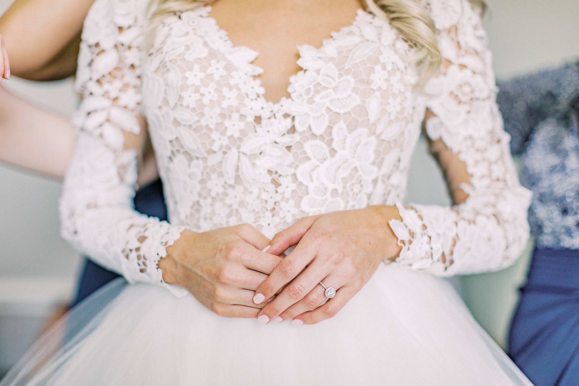 bride holds hands in front of lace bodice of hayden olivia bridal gown