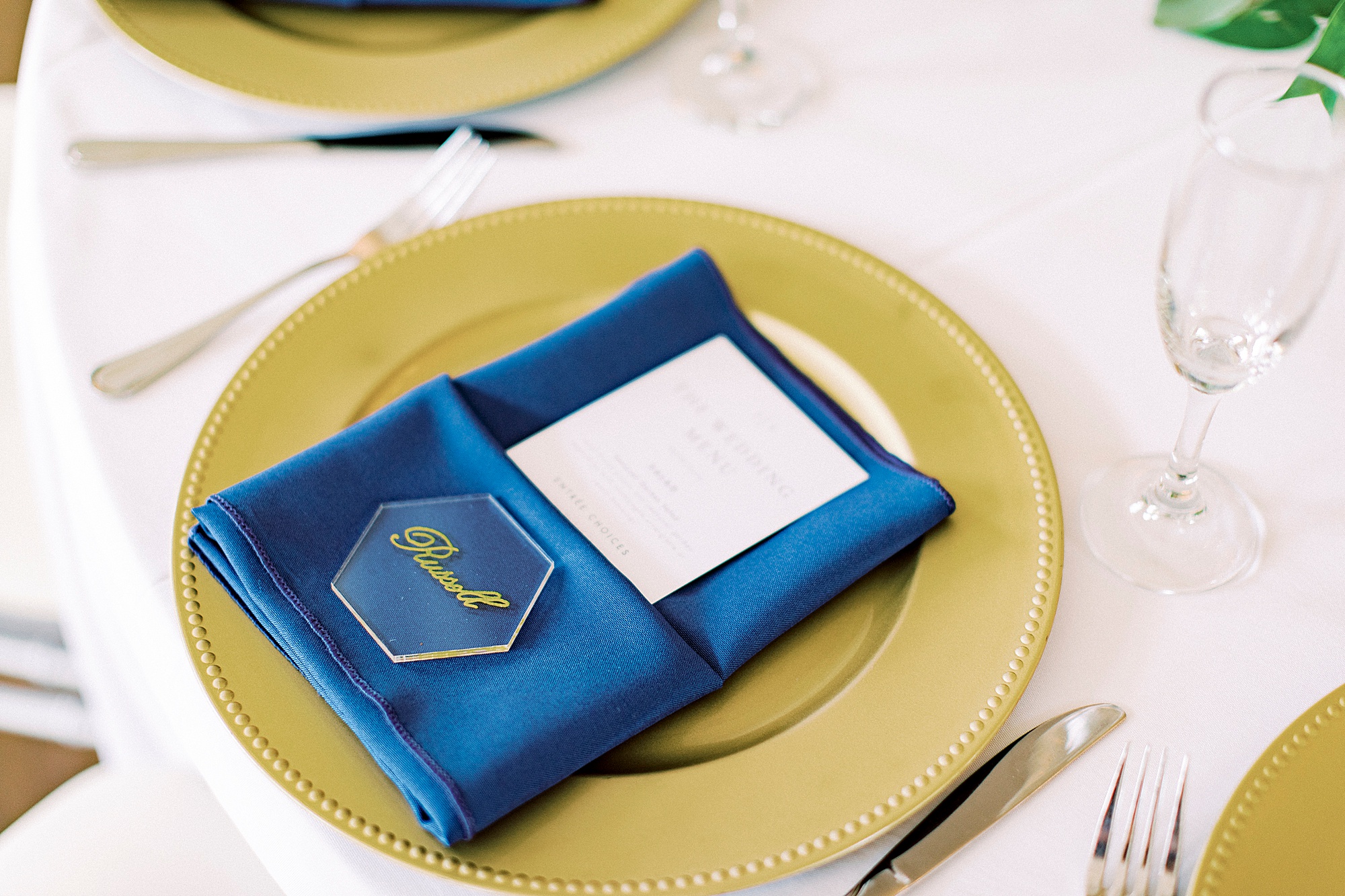 place setting with gold charger and navy napkin