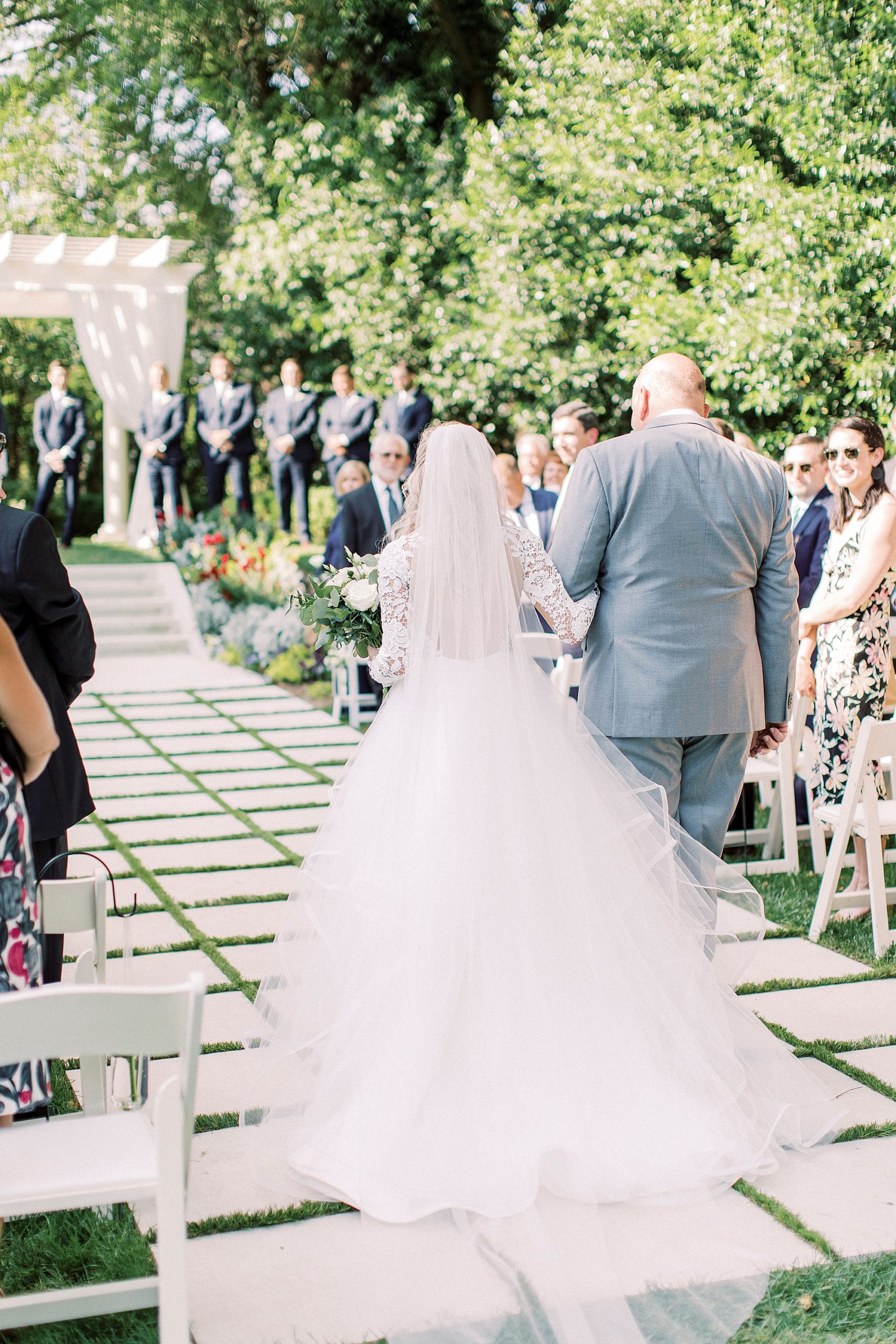 bride in Hayden Olivia bridal gown walks into garden wedding ceremony at Separk Mansion