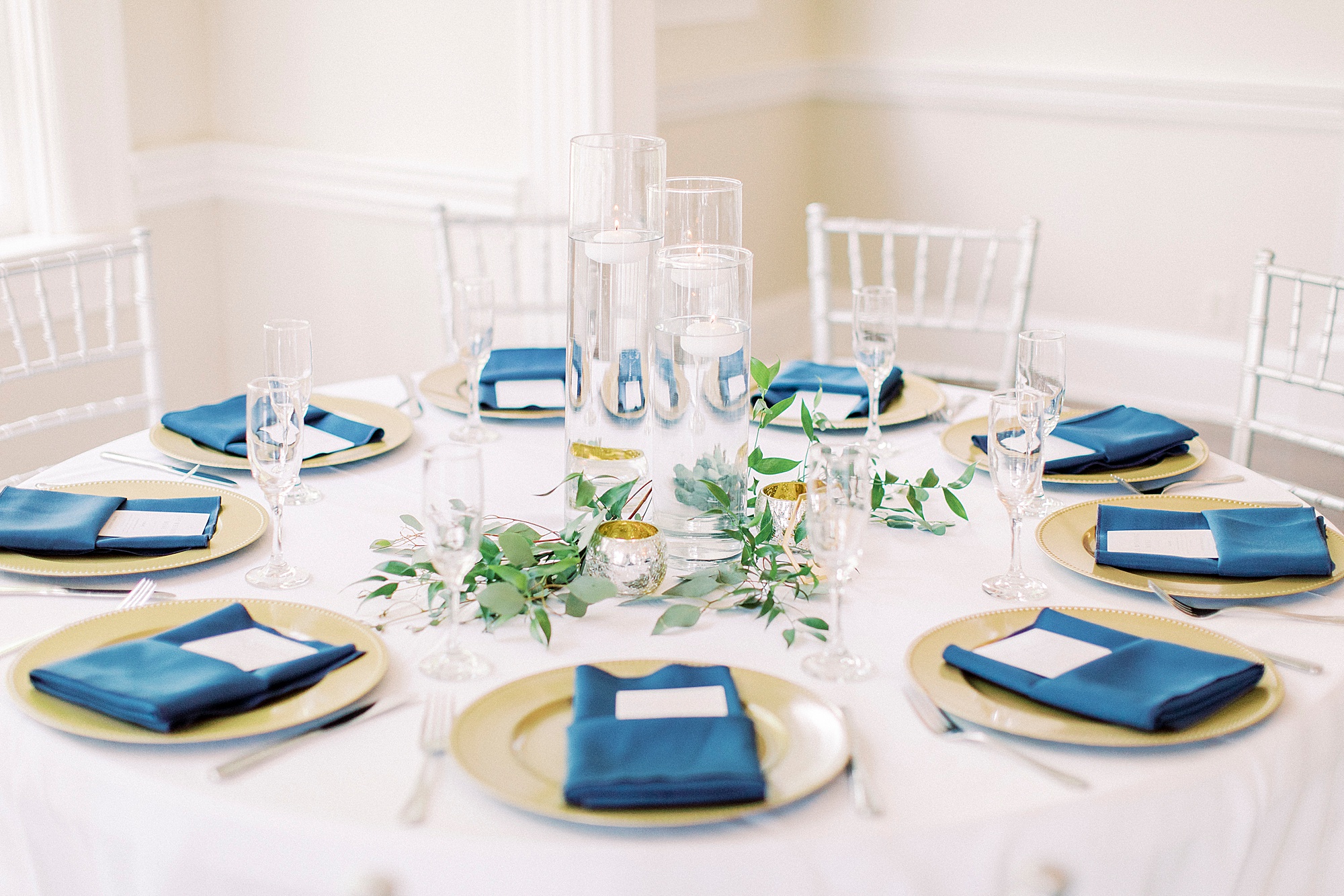 place settings with gold chargers and blue napkins
