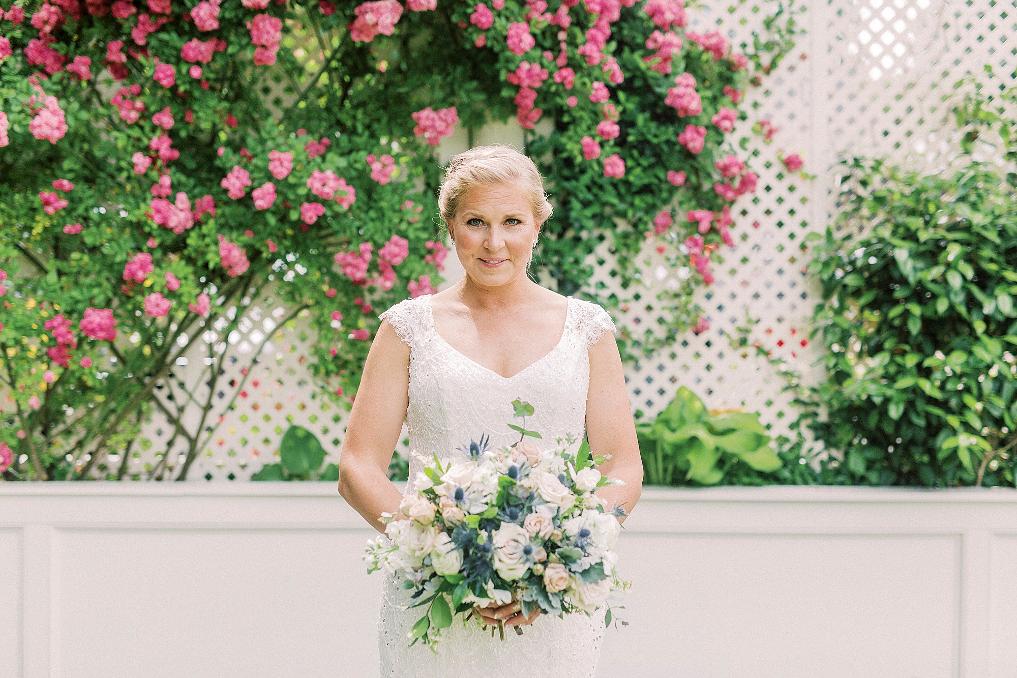 bride holds bouquet by pink tree in garden at Separk Mansion
