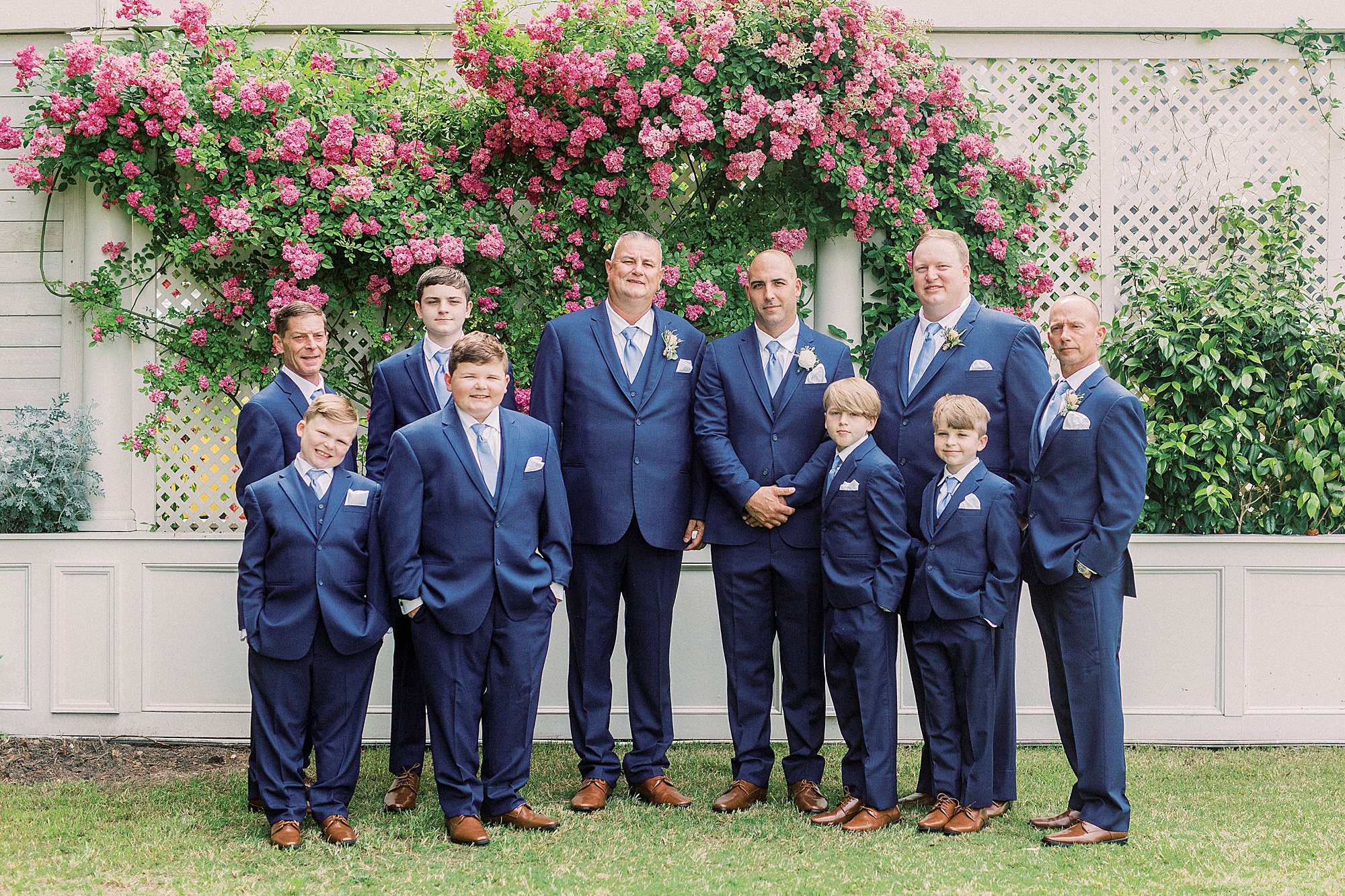 groom poses with groomsmen in navy suits in gardens at Separk Mansion