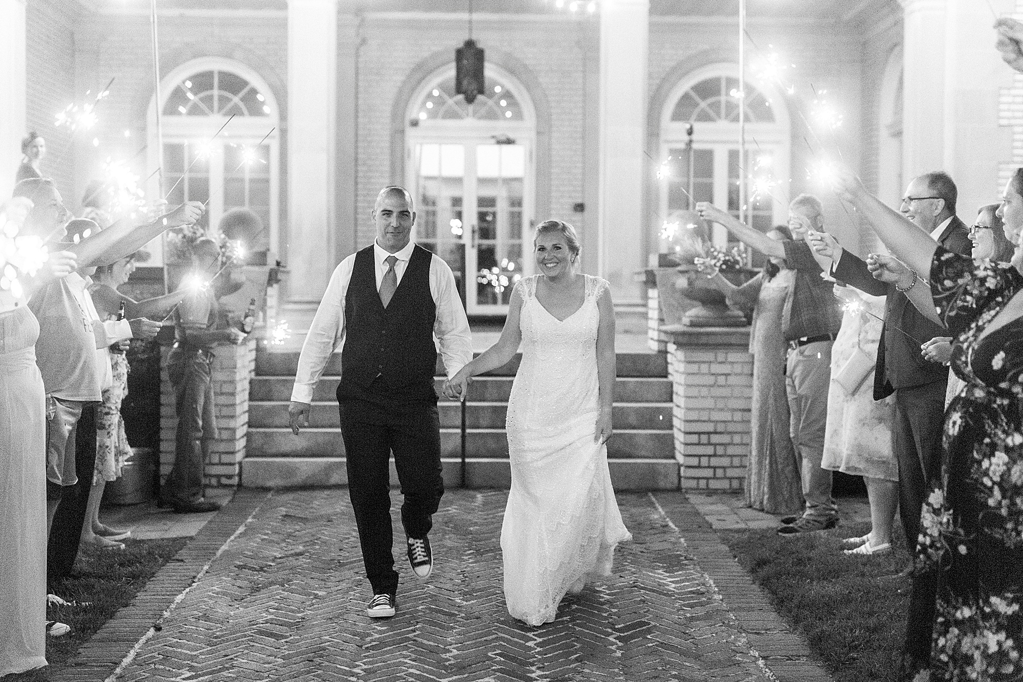 bride and groom leave wedding reception in sparkler exit