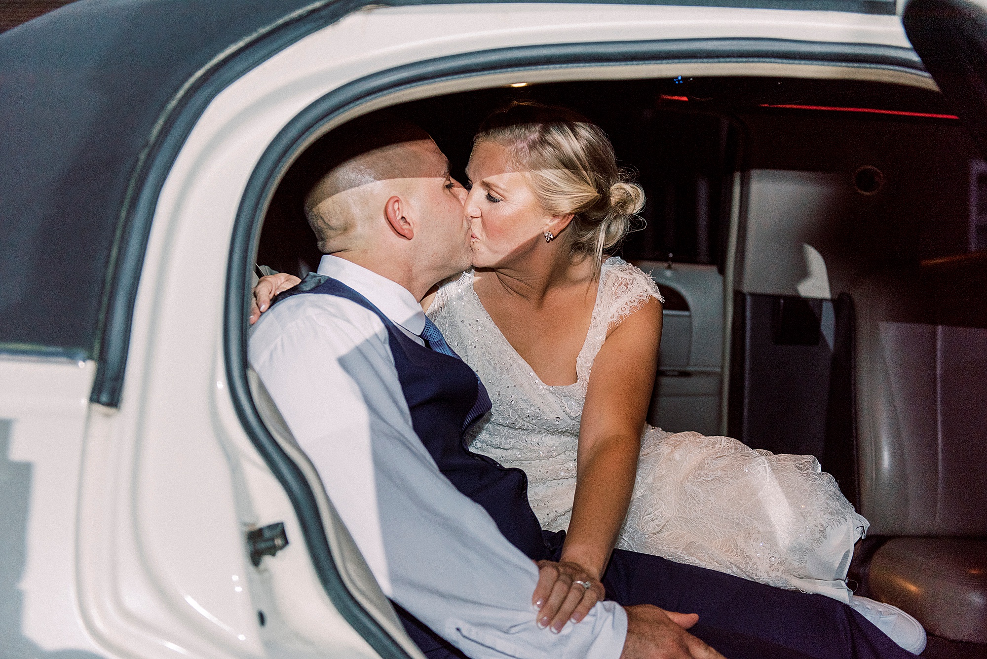 newlyweds kiss in getaway car after wedding ceremony in CHarlotte NC