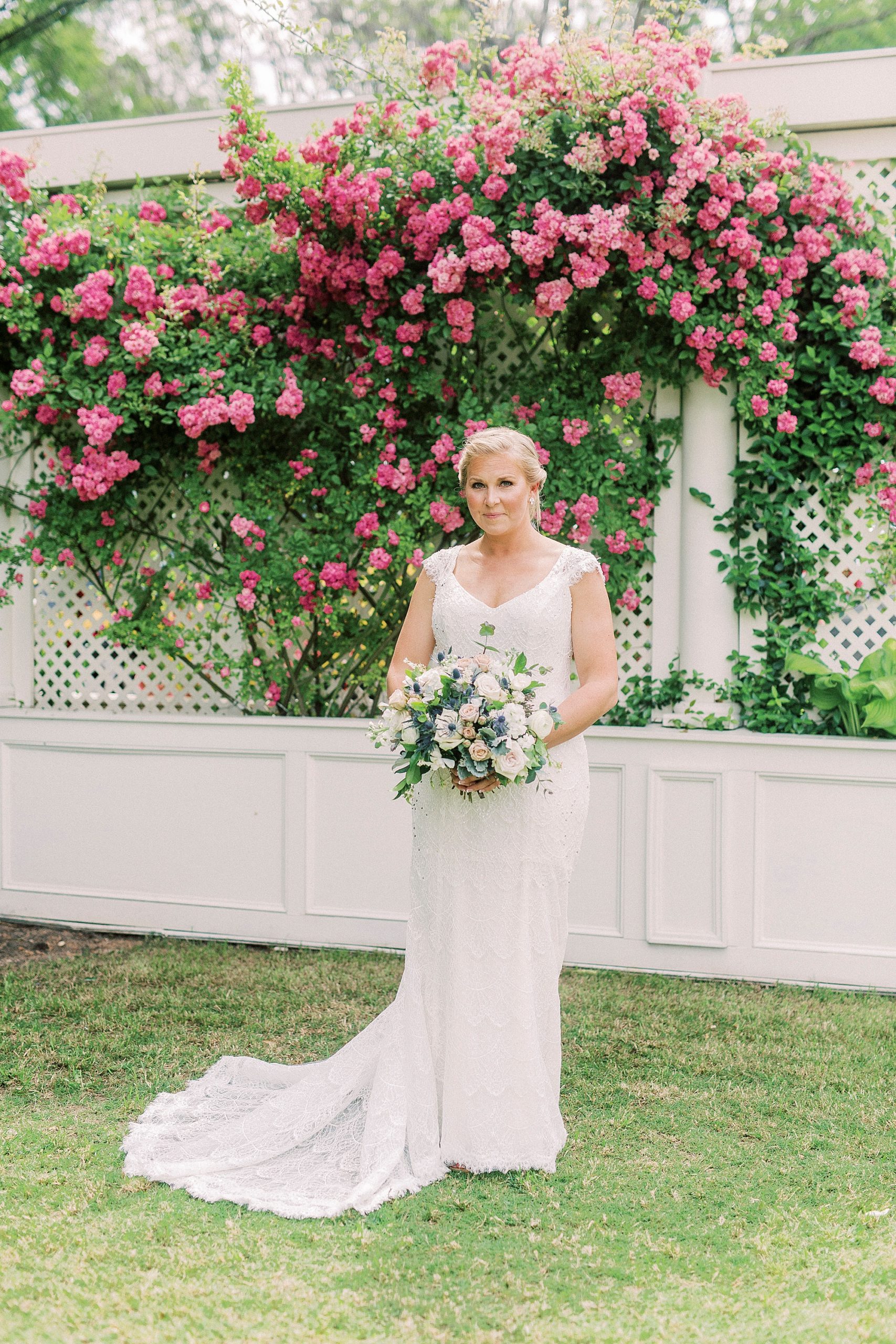 bride holds bouquet in gardens by pink flowers