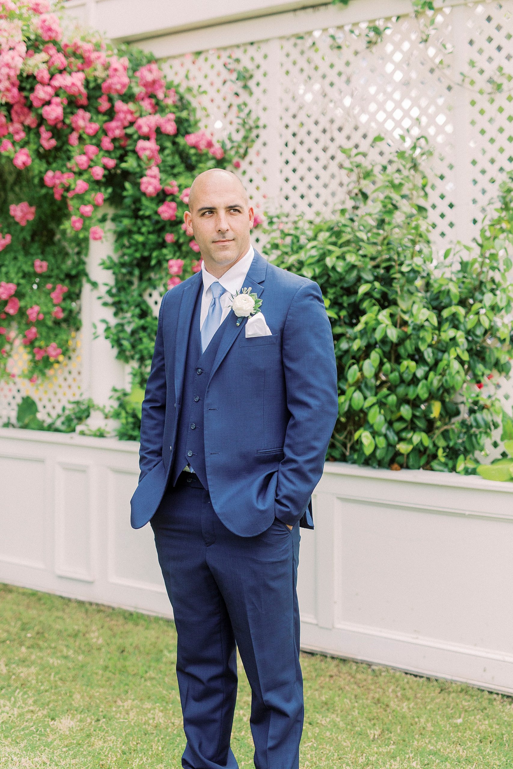 groom in navy suit stand in gardens of Charlotte NC venue
