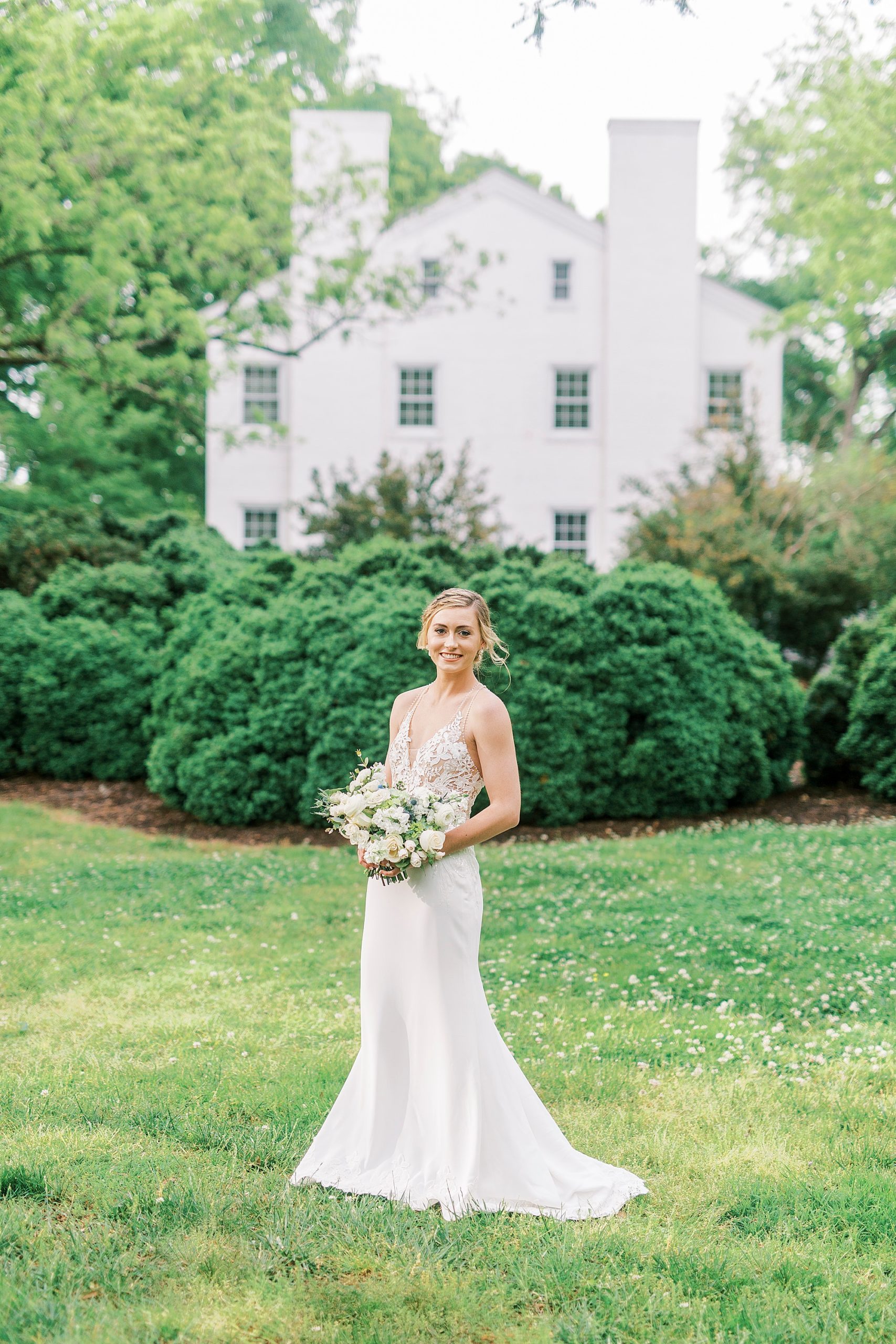 bride holds bouquet of white and green flowers at Tanglewood Park