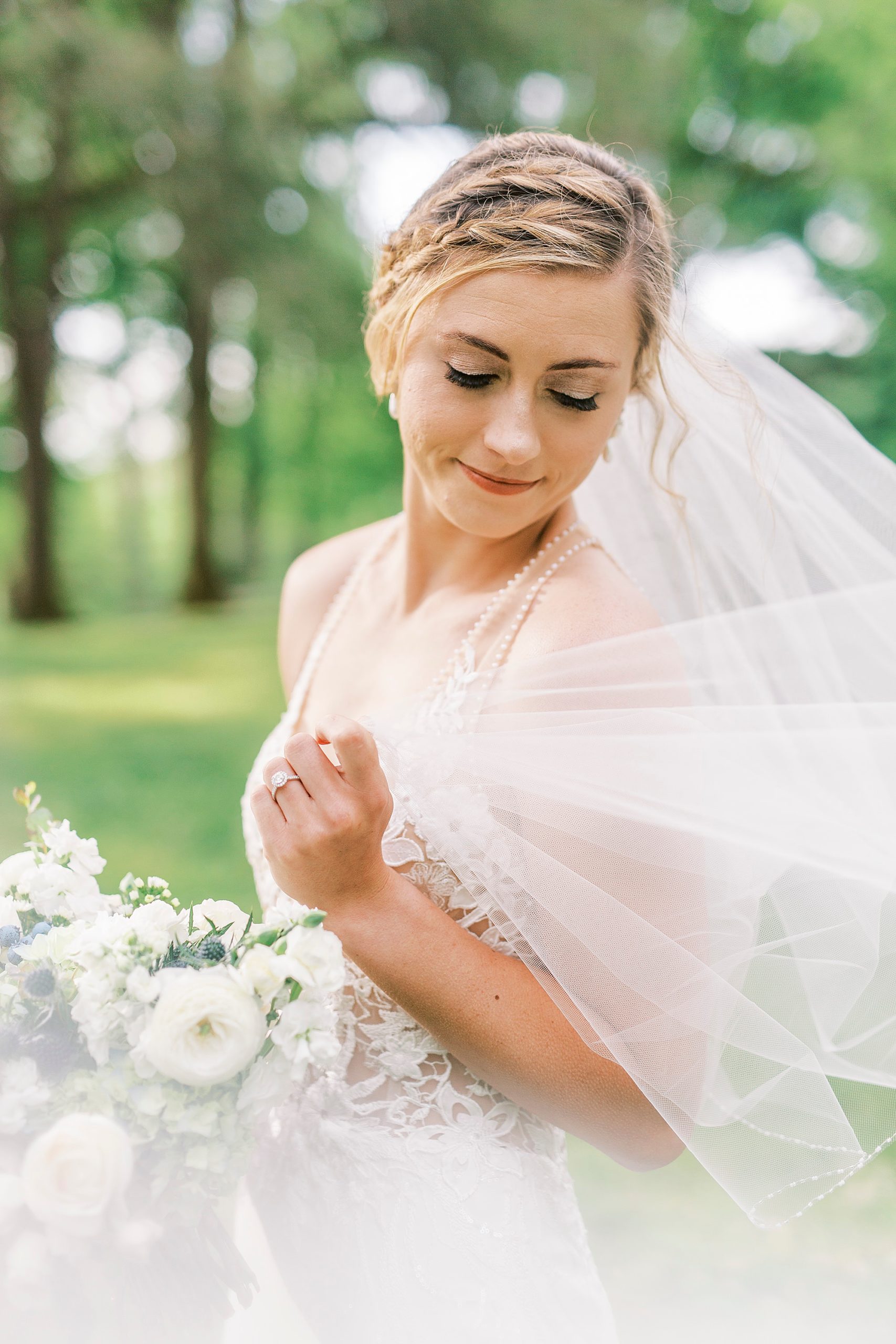 bride holds veil around her shoulders