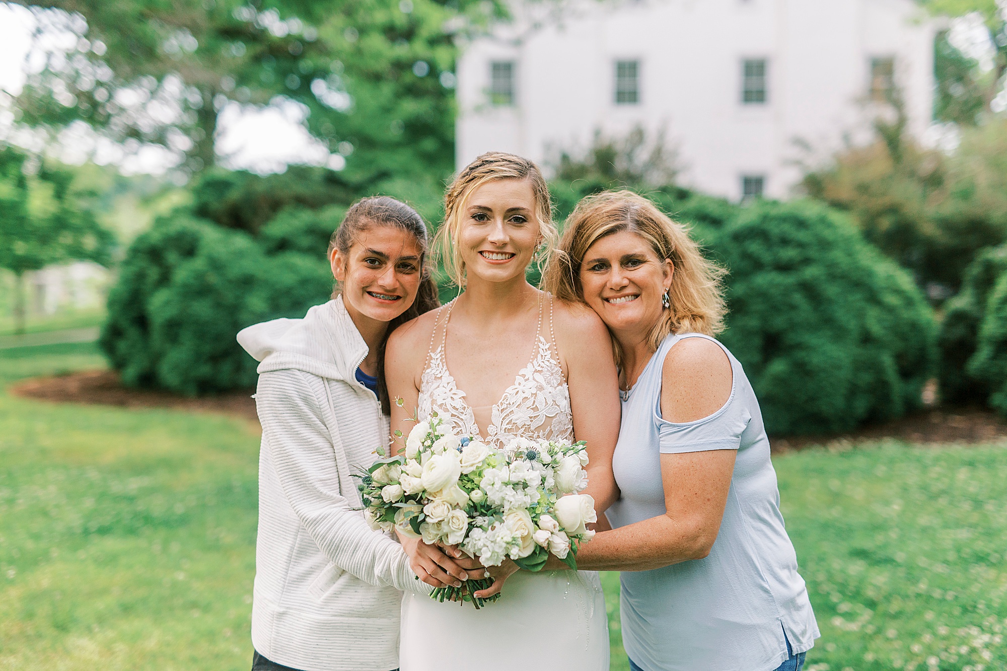 bride hugs mom and sister during portraits at Tanglewood Park