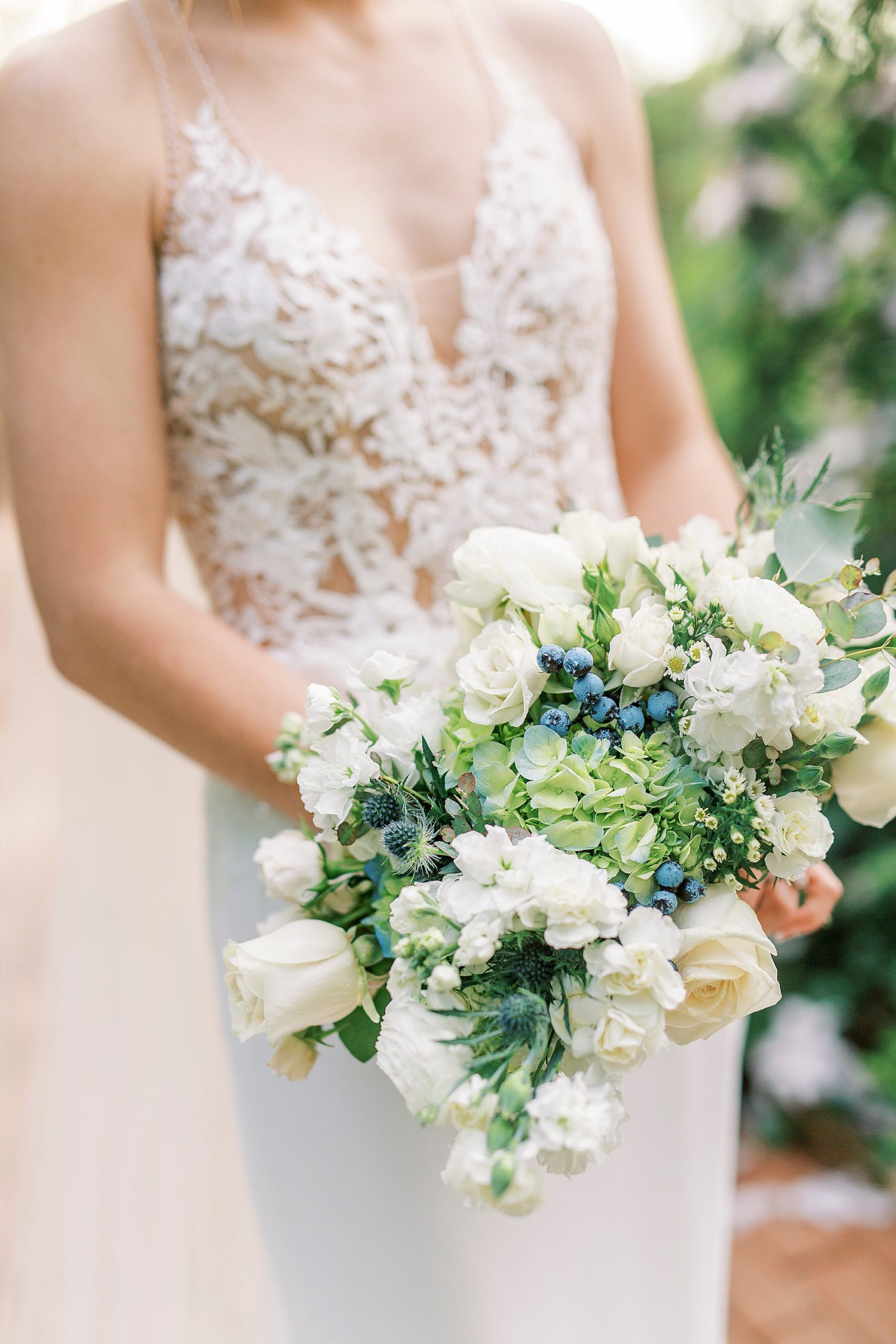 bride holds bouquet of white and green flowers during Tanglewood bridal portraits