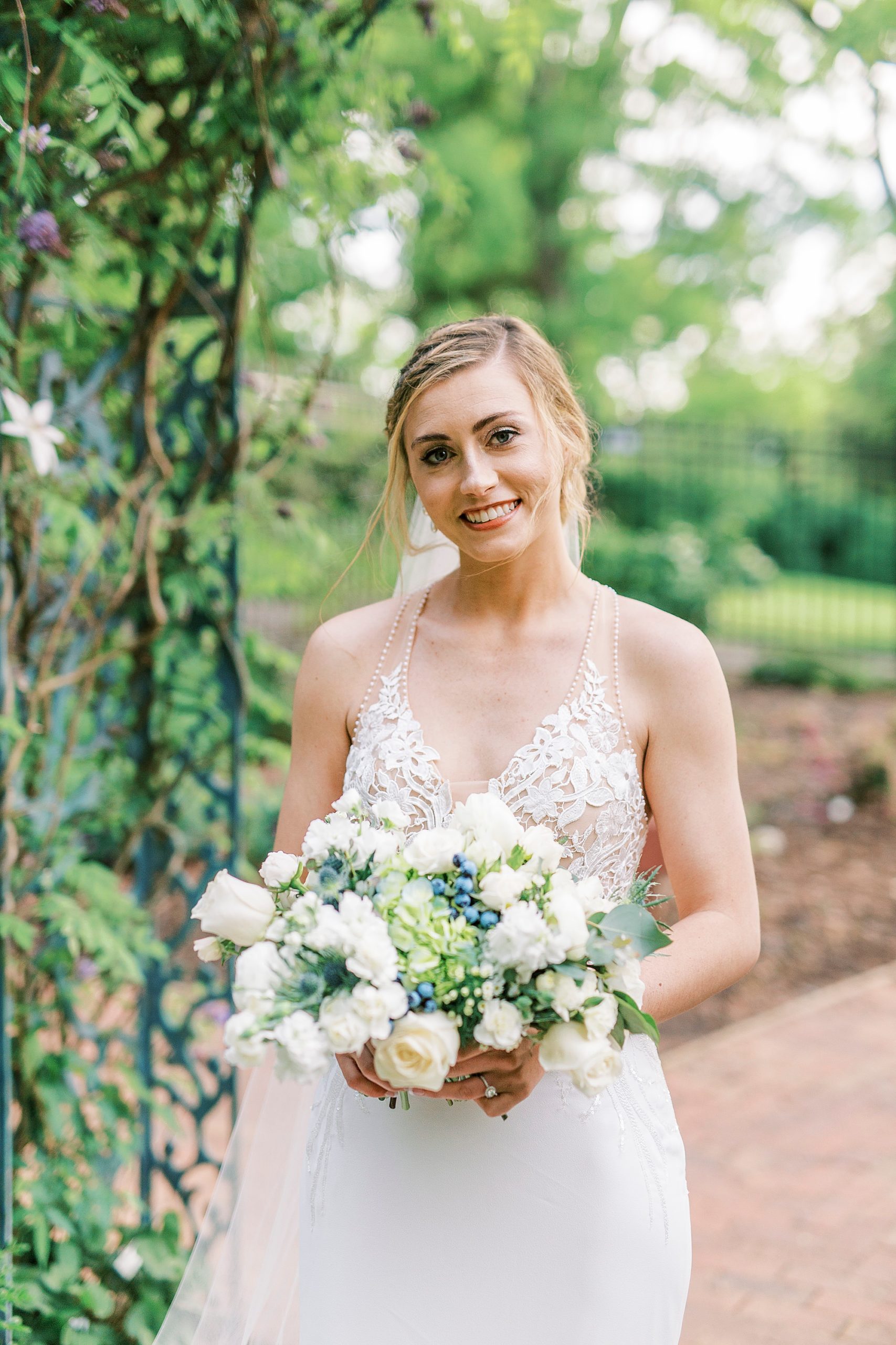 bride holds bouquet of white and green flowers in Tanglewood Park
