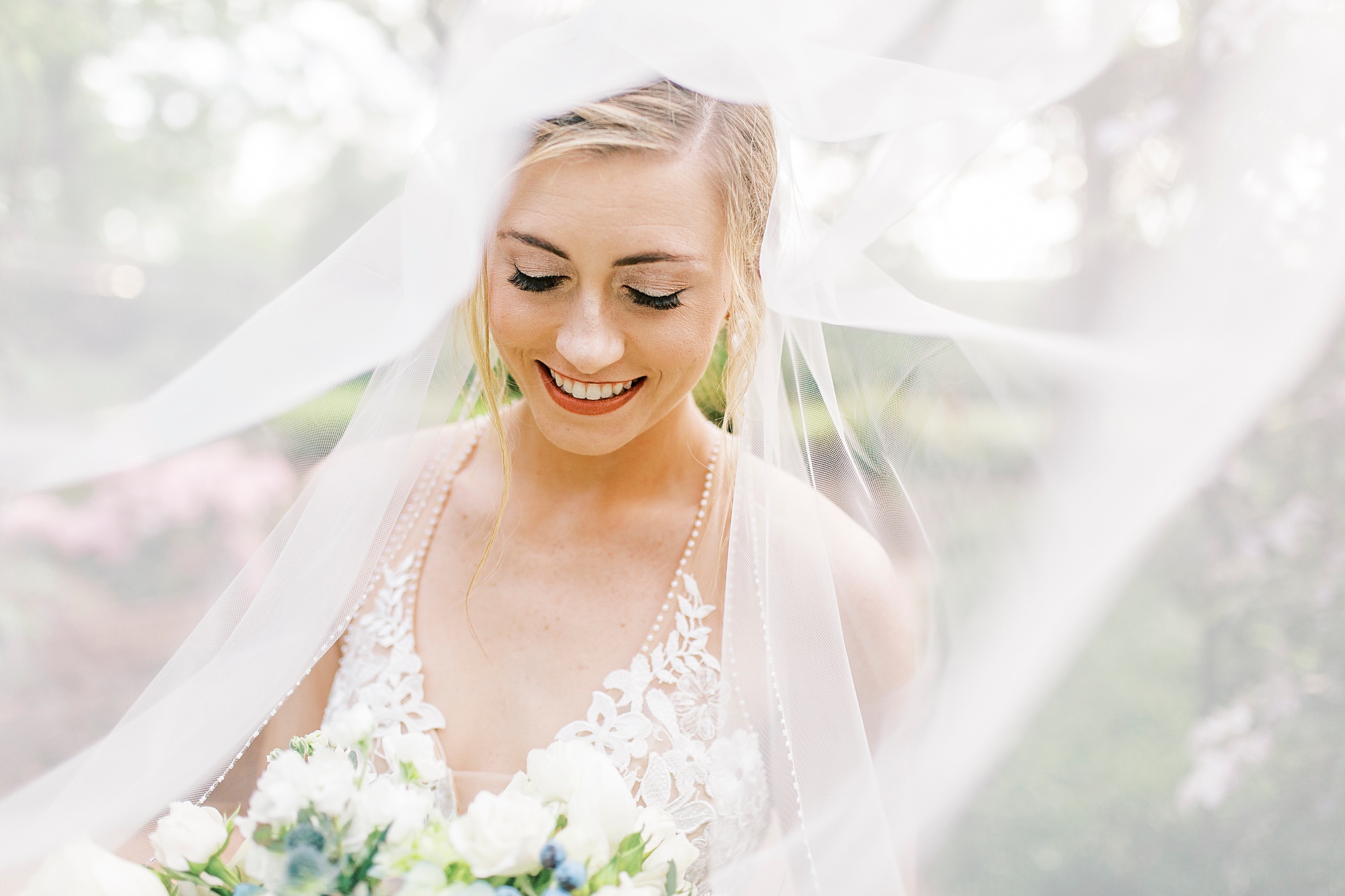 bride laughs under veil during bridal portraits