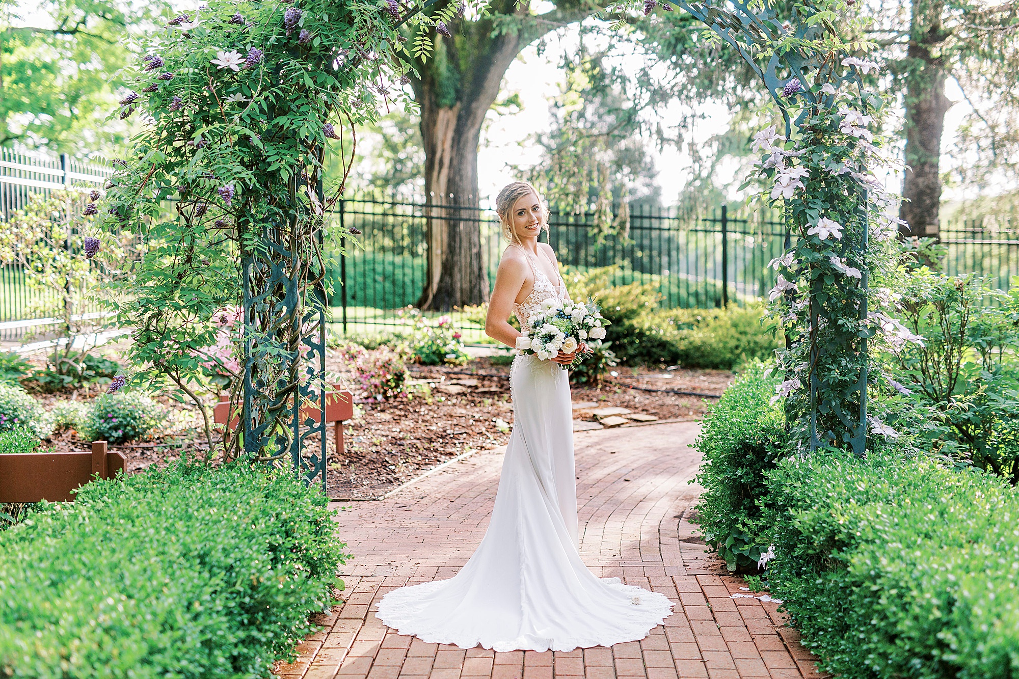 bride poses under arbor at Tanglewood Park
