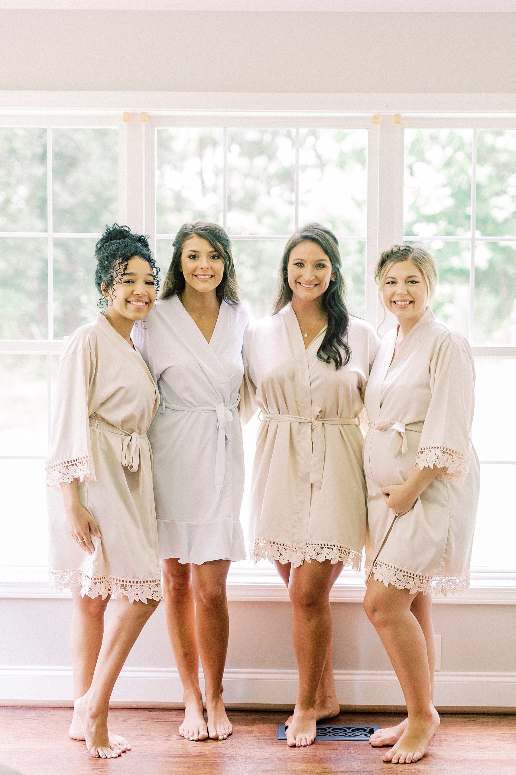 bride poses with bridesmaids in ivory robes