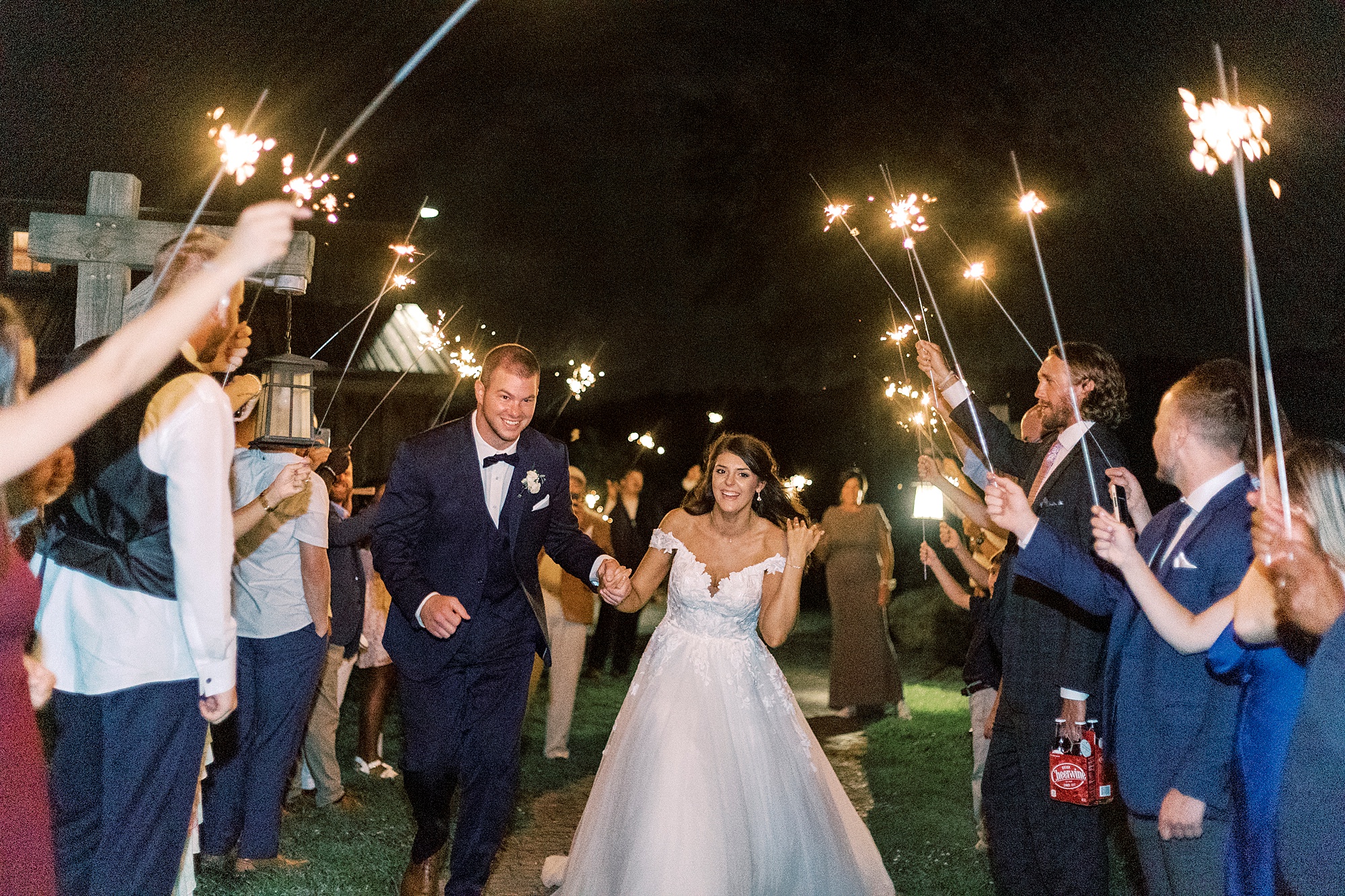 bride and groom walk through sparklers during NC wedding day exit