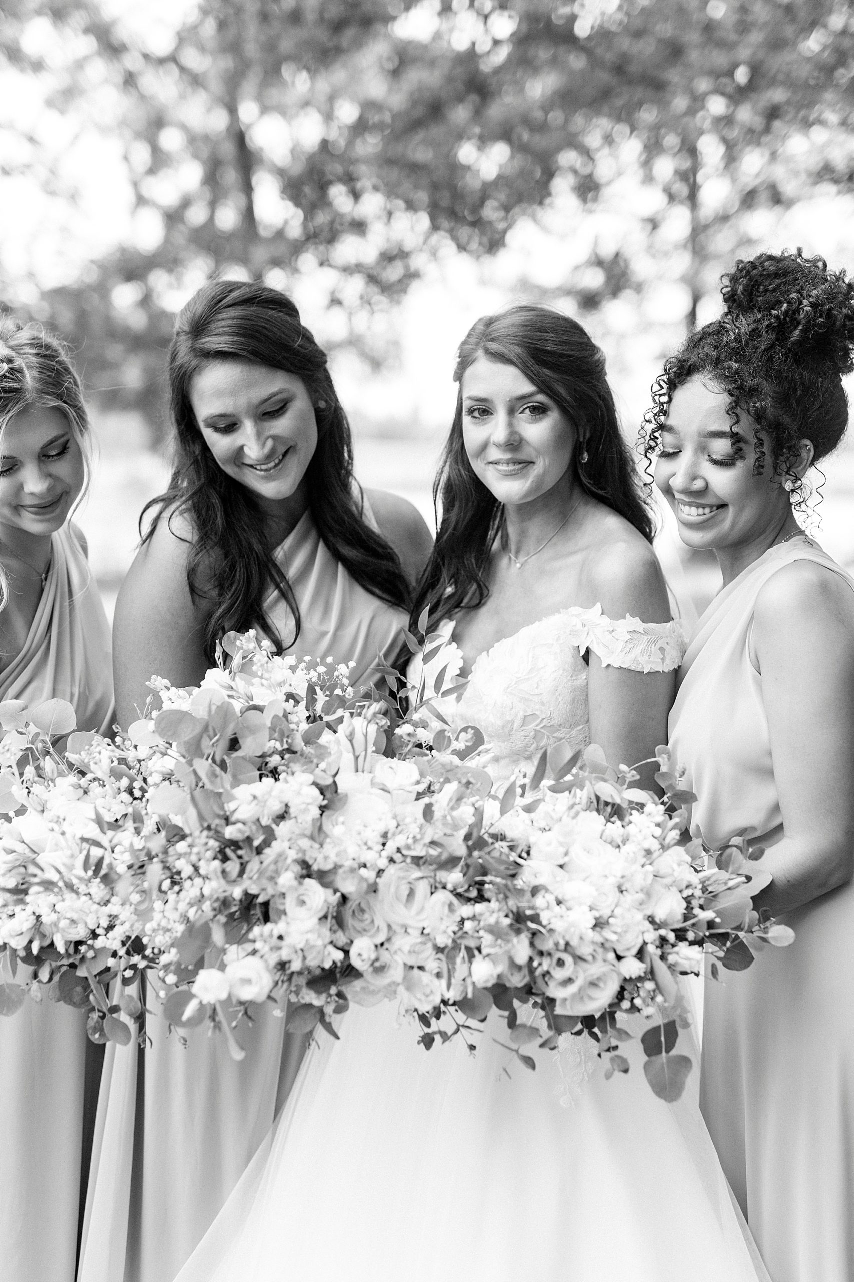 bride and bridesmaids pose together before The Farmstead wedding