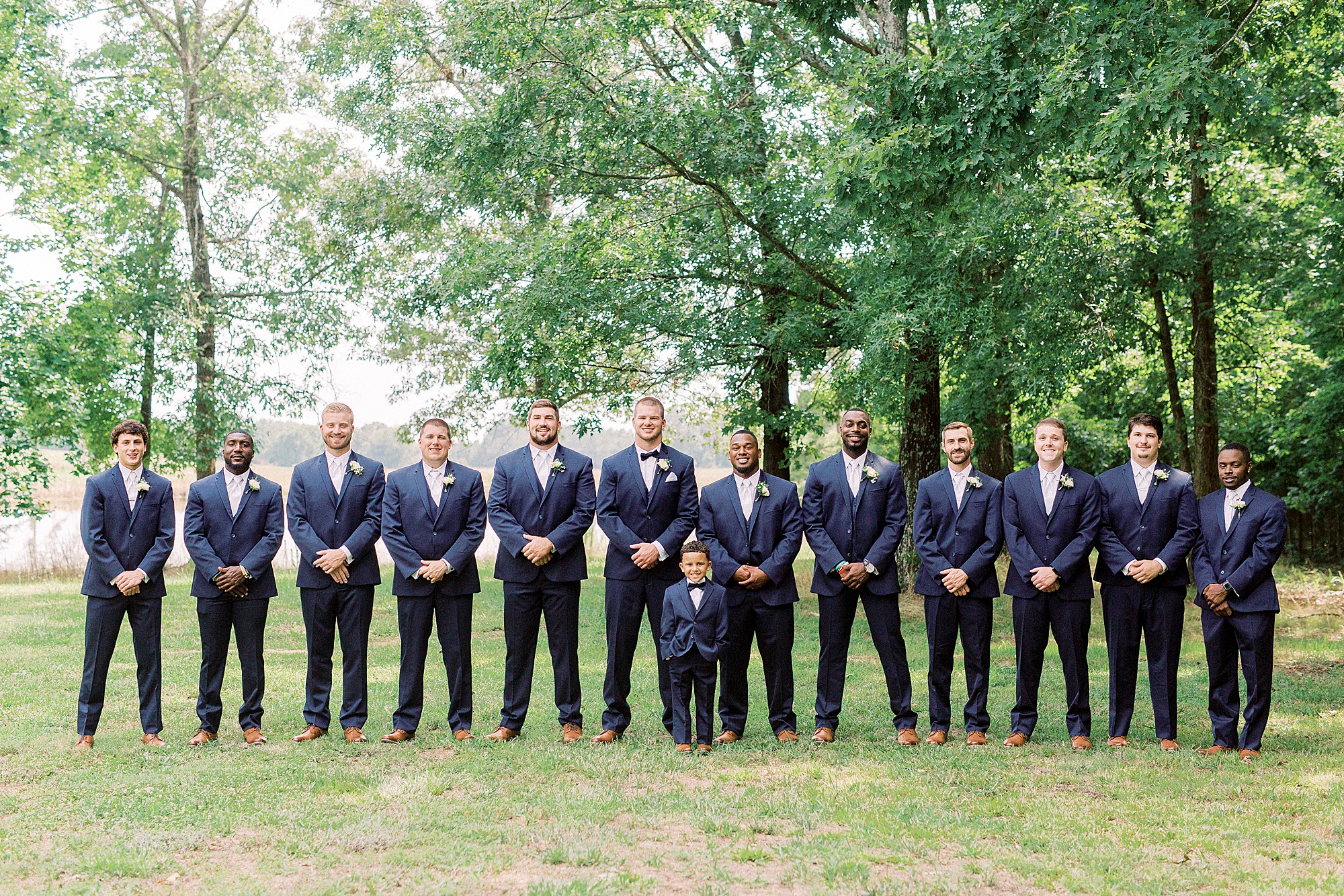 groom and groomsmen pose at The Farmstead in navy suits