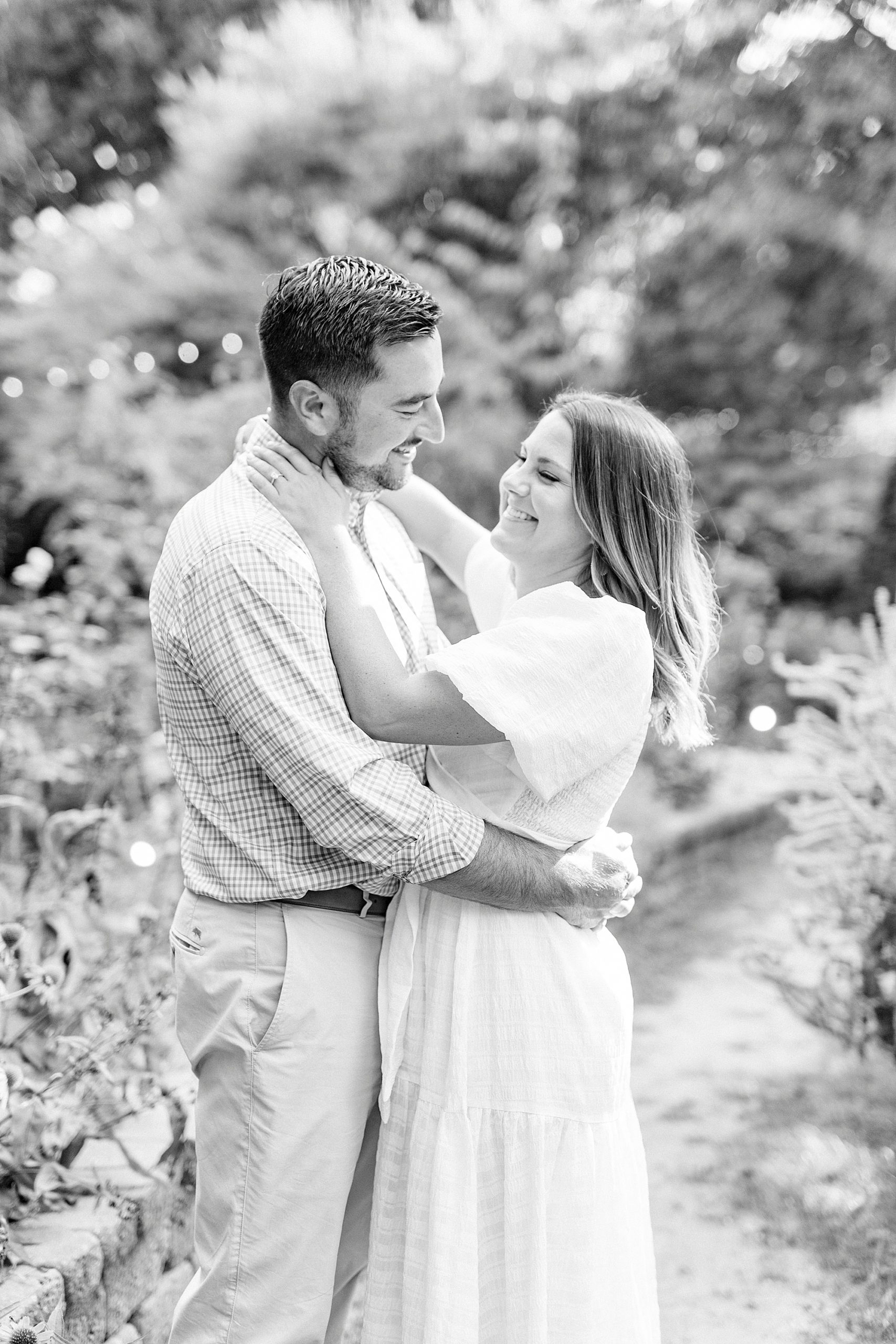 bride holds groom's face during engagement session at McGill Rose Garden