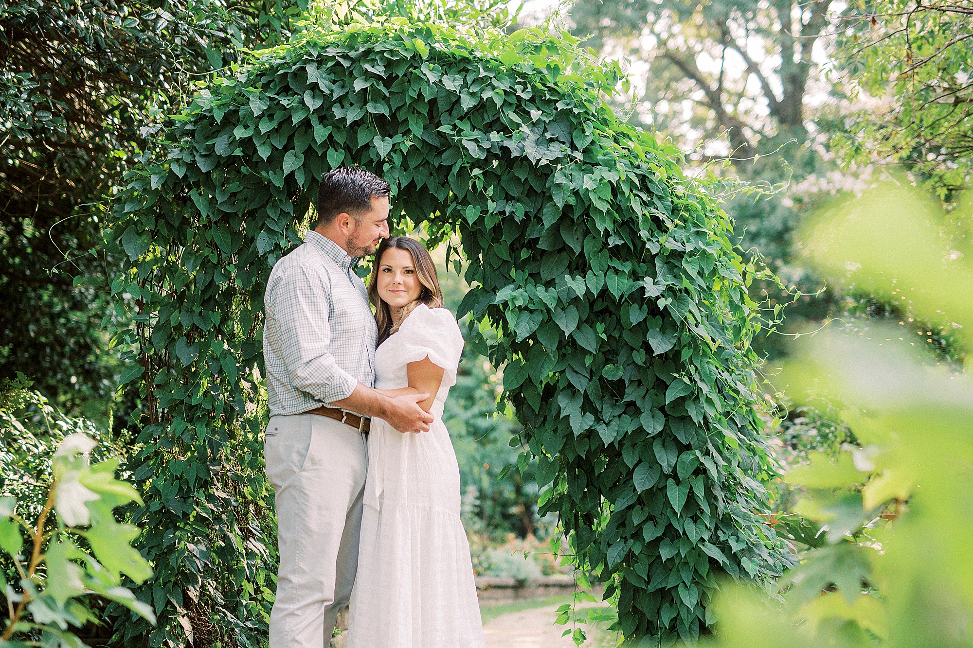 bride and groom hug under ivy archway in Charlotte NC