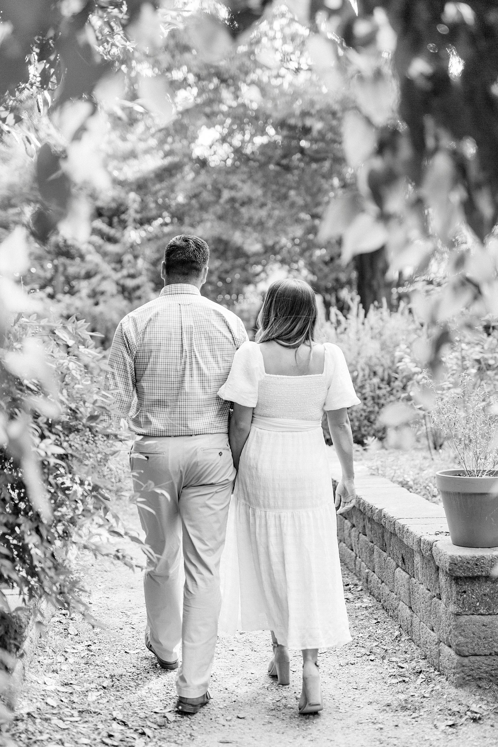 bride and groom walk together during McGill Rose Garden engagement session
