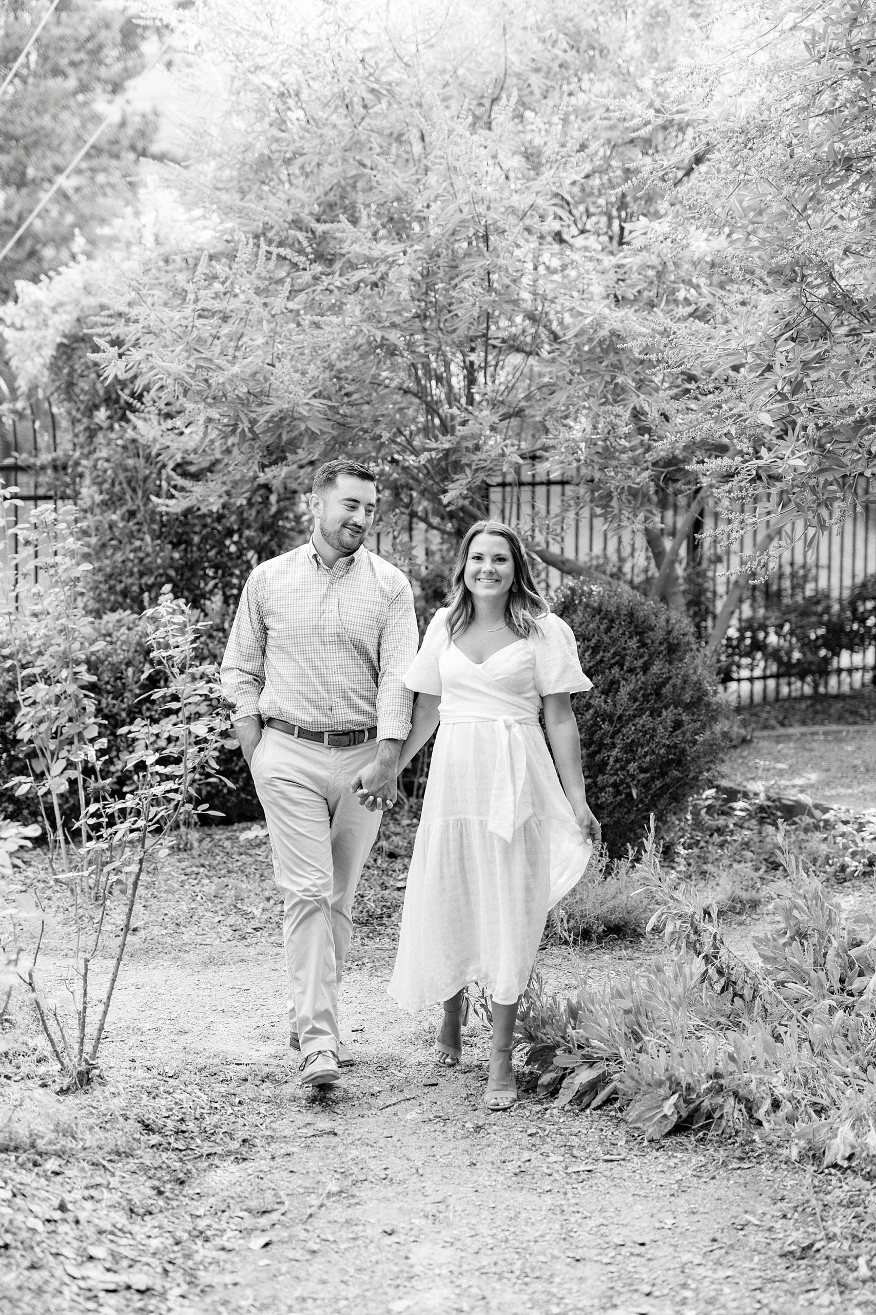 engaged couple walks through McGill Rose Garden