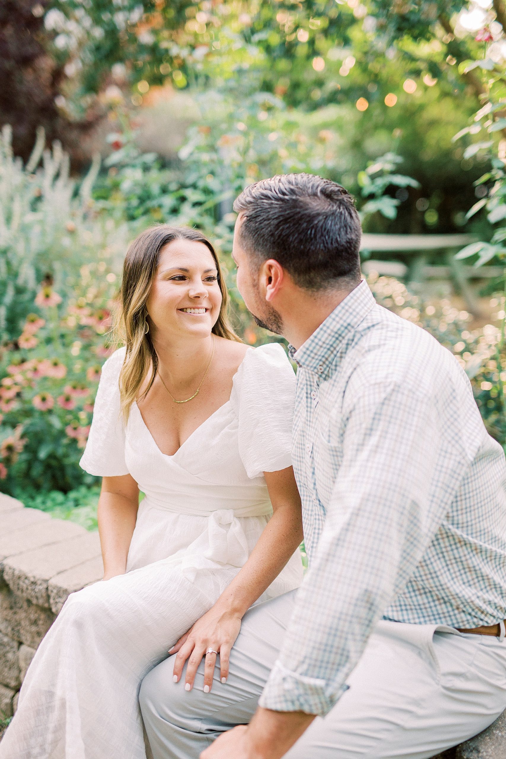 couple smiles at each other during McGill Rose Garden engagement session