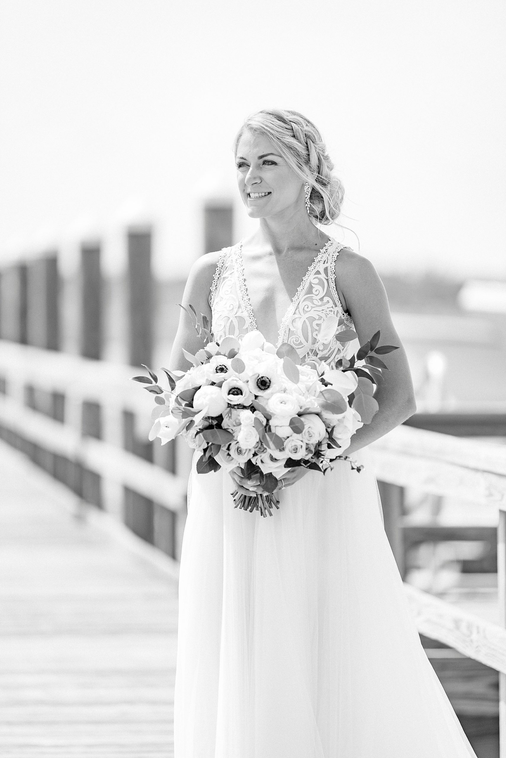bride holds bouquet in dress with lace details