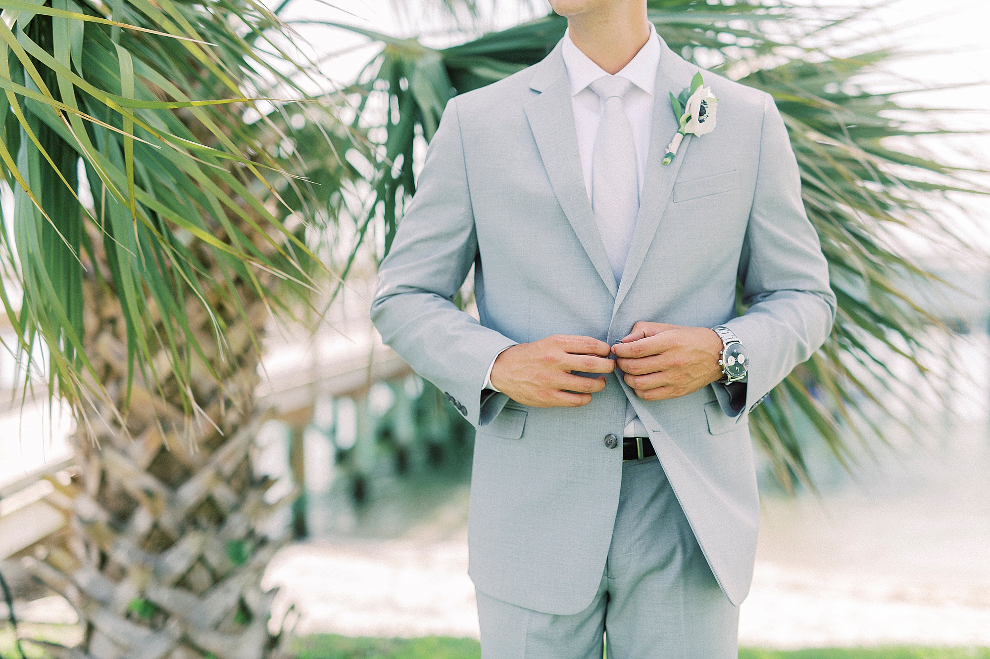 groom adjusts suit jacket