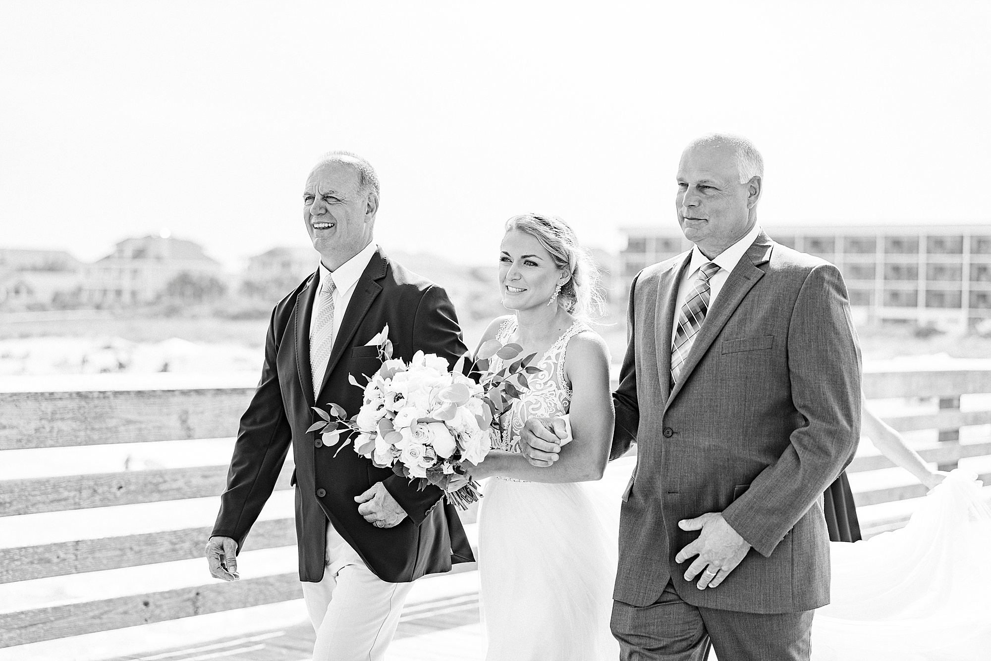 bride walks down aisle with dad and step dad
